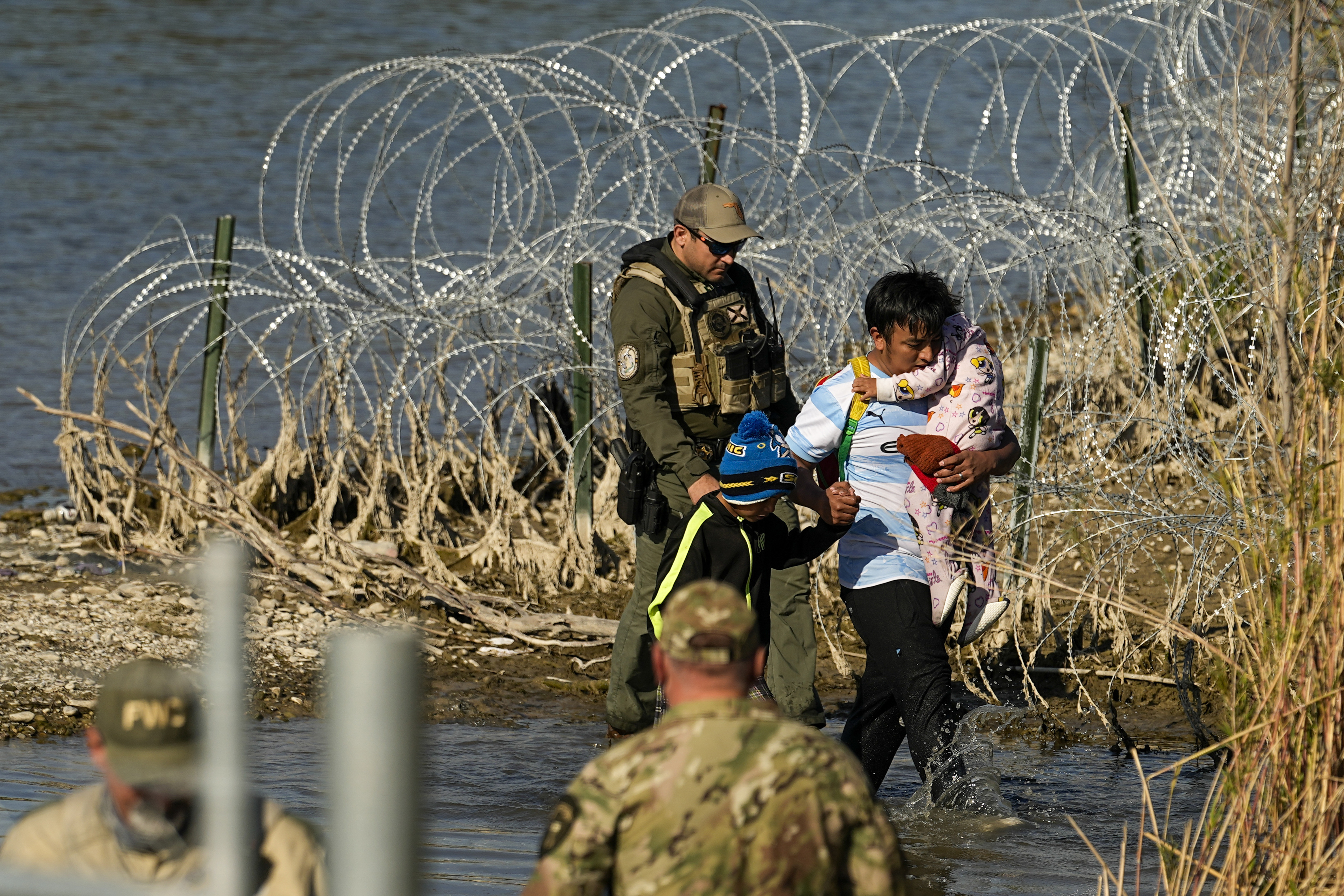FILE - Migrants are taken into custody by officials at the Texas-Mexico border, Jan. 3, 2024, in Eagle Pass, Texas. A federal judge on Friday, June 28, 2024, approved the Biden administration’s request to partially end a nearly three-decade-old agreement to provide court oversight of how the government cares for migrant children in its custody. (AP Photo/Eric Gay, file)