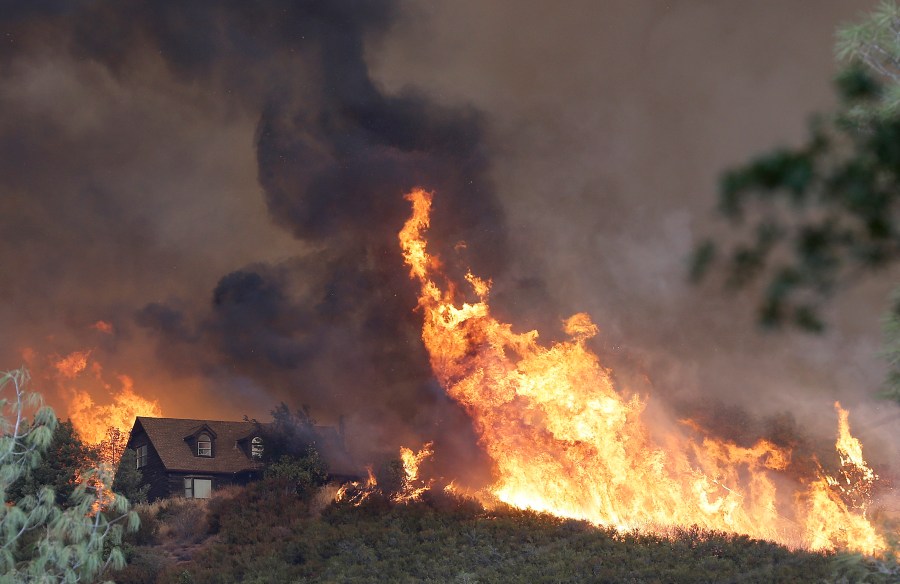 Fires approach a home near Lower Lake, Calif., Friday, July 31, 2015. A series of wildfires were intensified by dry vegetation, triple-digit temperatures and gusting winds. (AP Photo/Jeff Chiu)