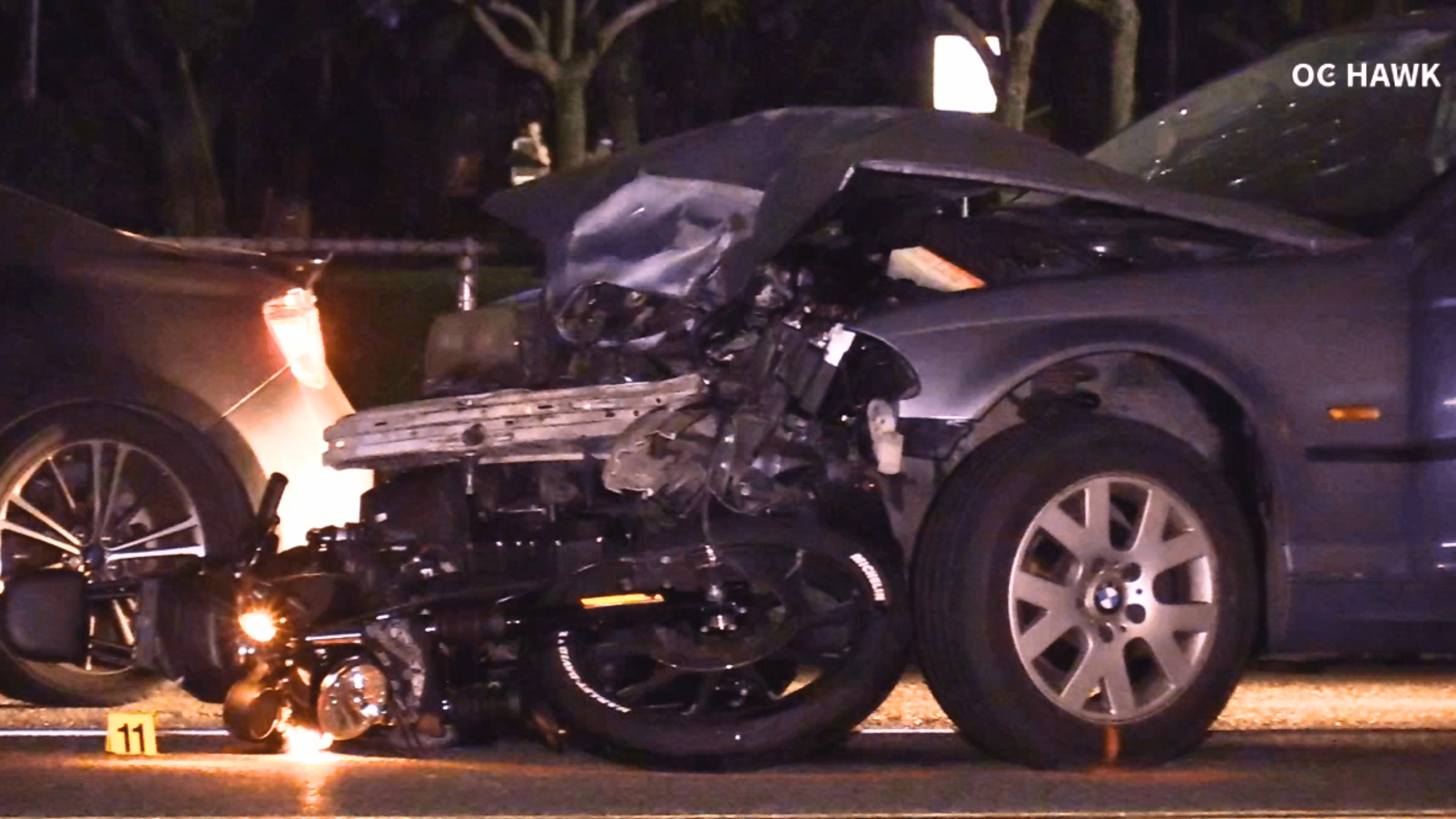 A motorcycle is seen wedged underneath a car after a fatal crash involving a suspected DUI driver in Fullerton on June 12, 2024. (OC Hawk)