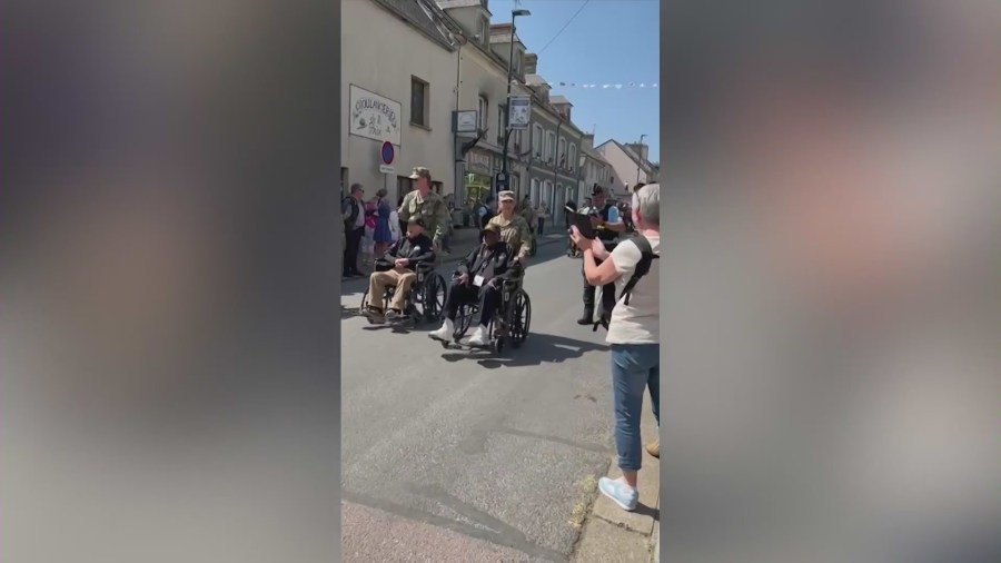 Louis Brown and other veterans make their way down a parade path in France as locals cheered them on in June 2024. (Brown Family)