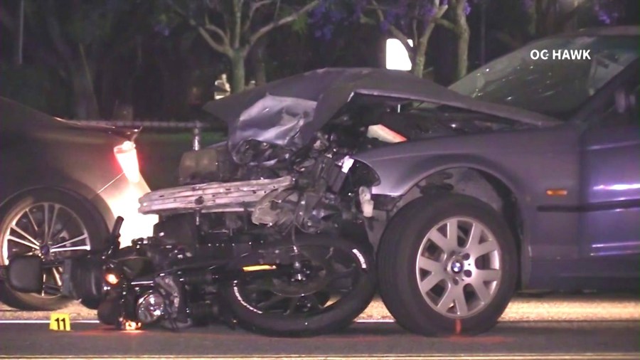 A motorcycle is seen wedged underneath a car after a fatal crash involving a suspected DUI driver in Fullerton on June 12, 2024. (OC Hawk)