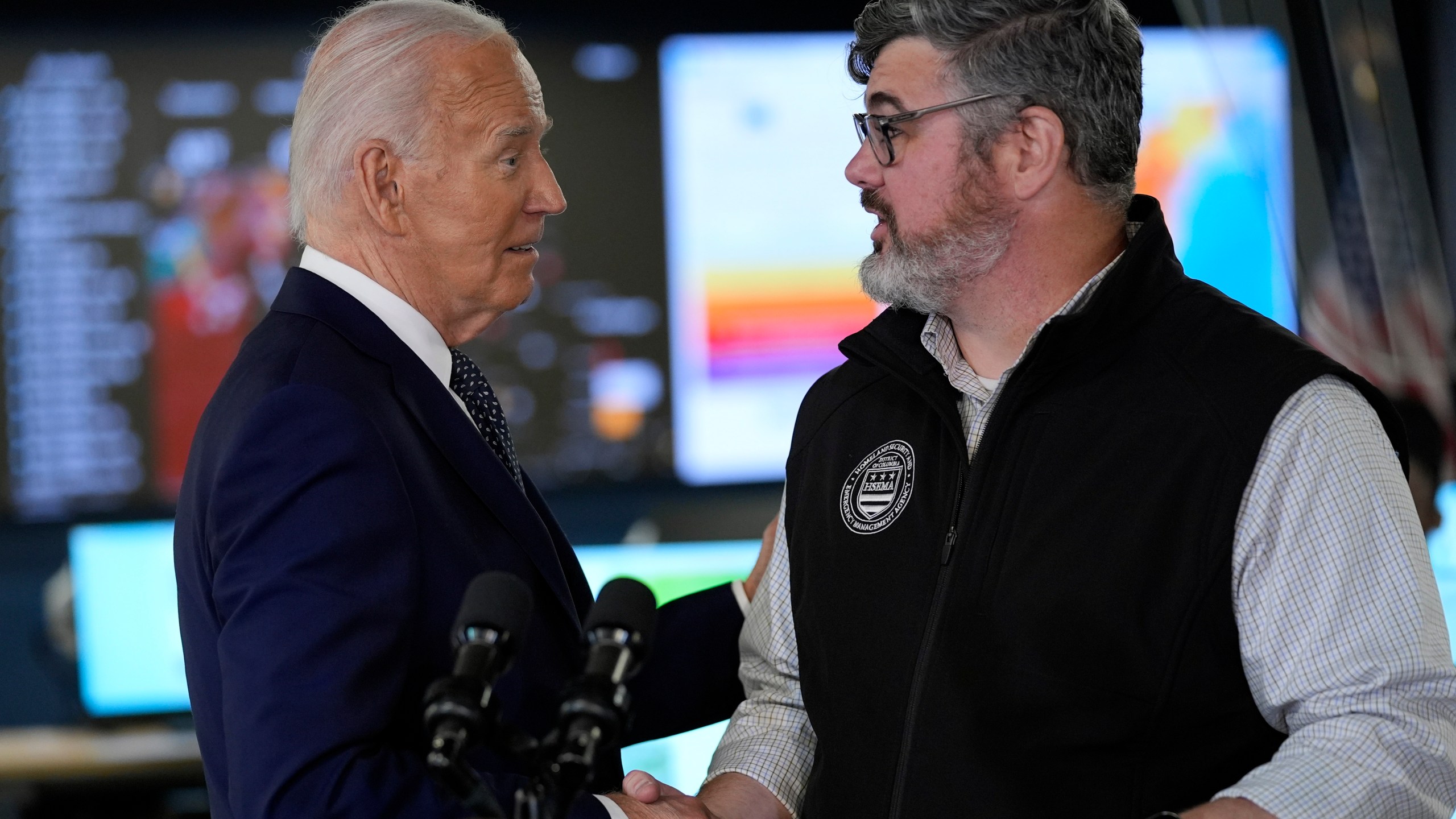 President Joe Biden greets Clint Osborn, acting director of the D.C. Homeland Security and Emergency Management Agency, after he spoke during a visit to the D.C. Emergency Operations Center, Tuesday, July 2, 2024, in Washington. (AP Photo/Evan Vucci)