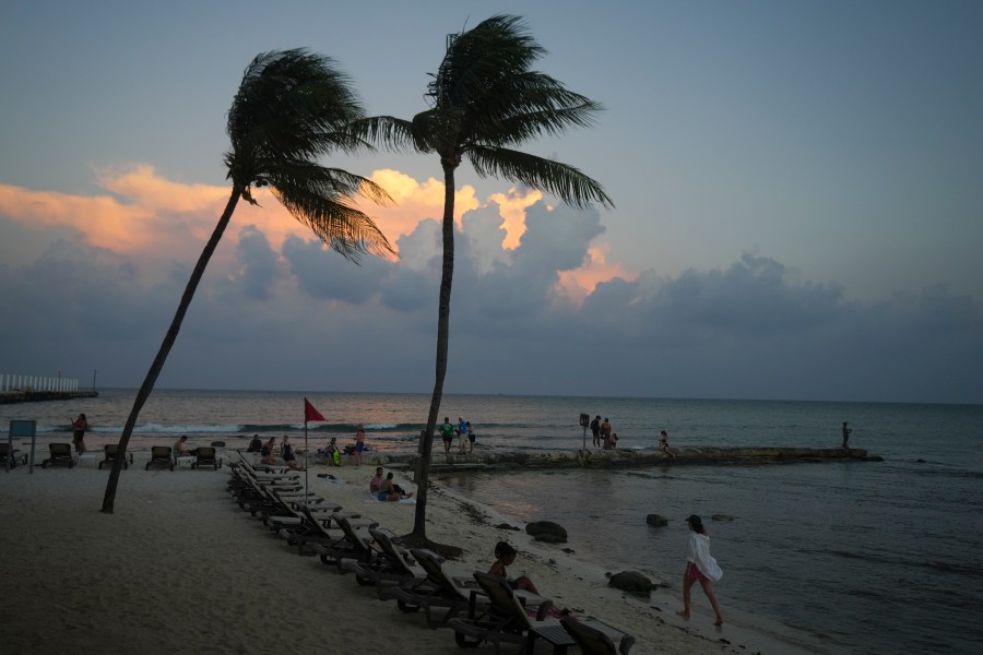 People lounge on the beach as the sun sets ahead of Hurricane Beryl's expected arrival, in Playa del Carmen, Mexico, Wednesday, July 3, 2024. (AP Photo/Fernando Llano)