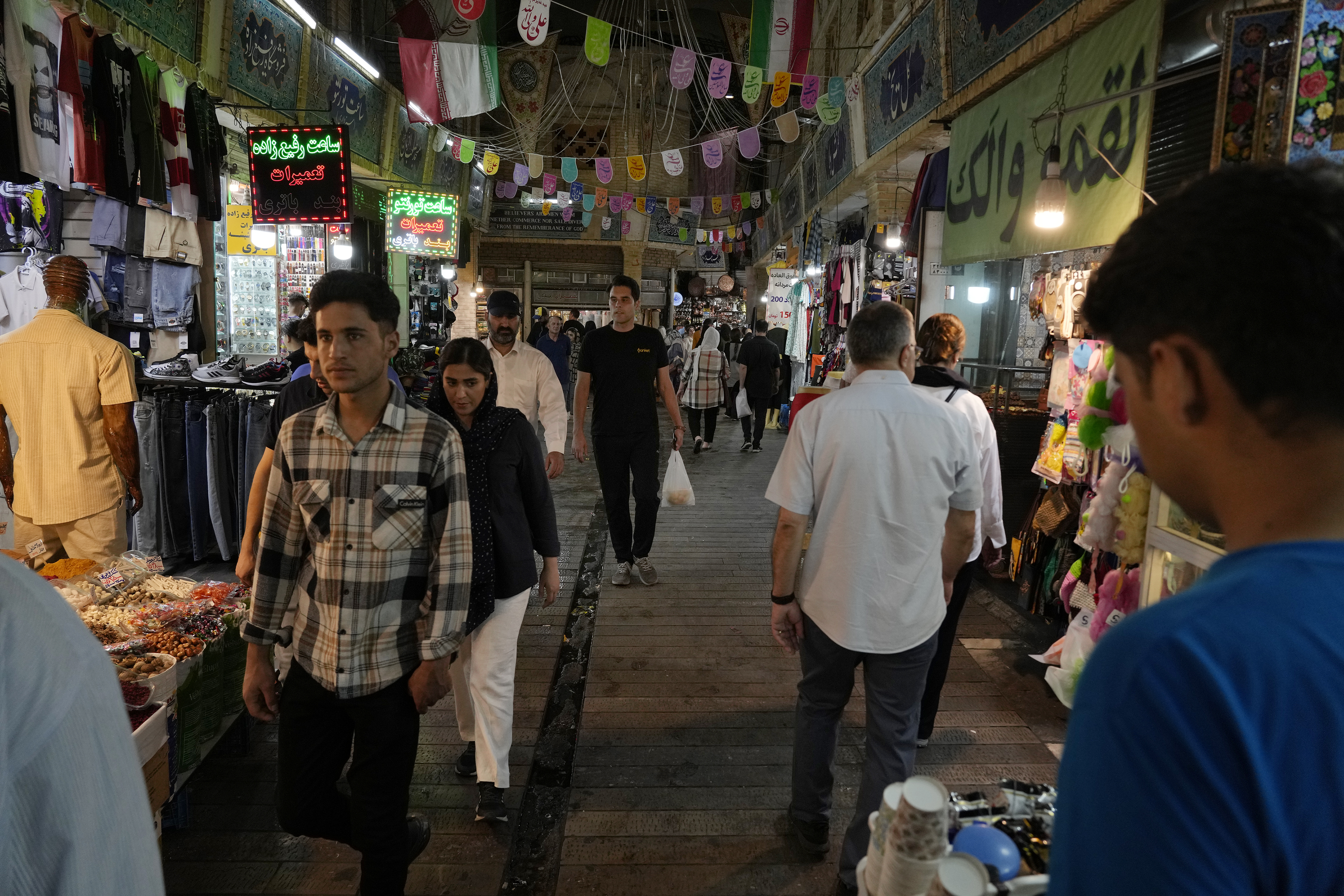 People walk through the Tajrish traditional bazaar in northern Tehran, Iran, Tuesday, July 2, 2024. Comments suggesting that Iran's reformist presidential candidate could increase government-set gasoline prices have raised fears of a repeat of nationwide protests. (AP Photo/Vahid Salemi)