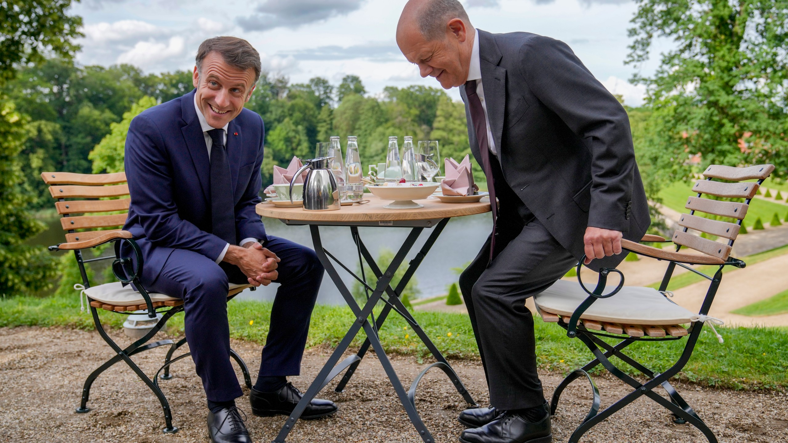 FILE - German Chancellor Olaf Scholz, right, and French President Emmanuel Macron sit at a table in the garden of the German government guest house in Meseberg, north of Berlin, Germany, on May 28, 2024. (AP Photo/Ebrahim Noroozi, Pool)