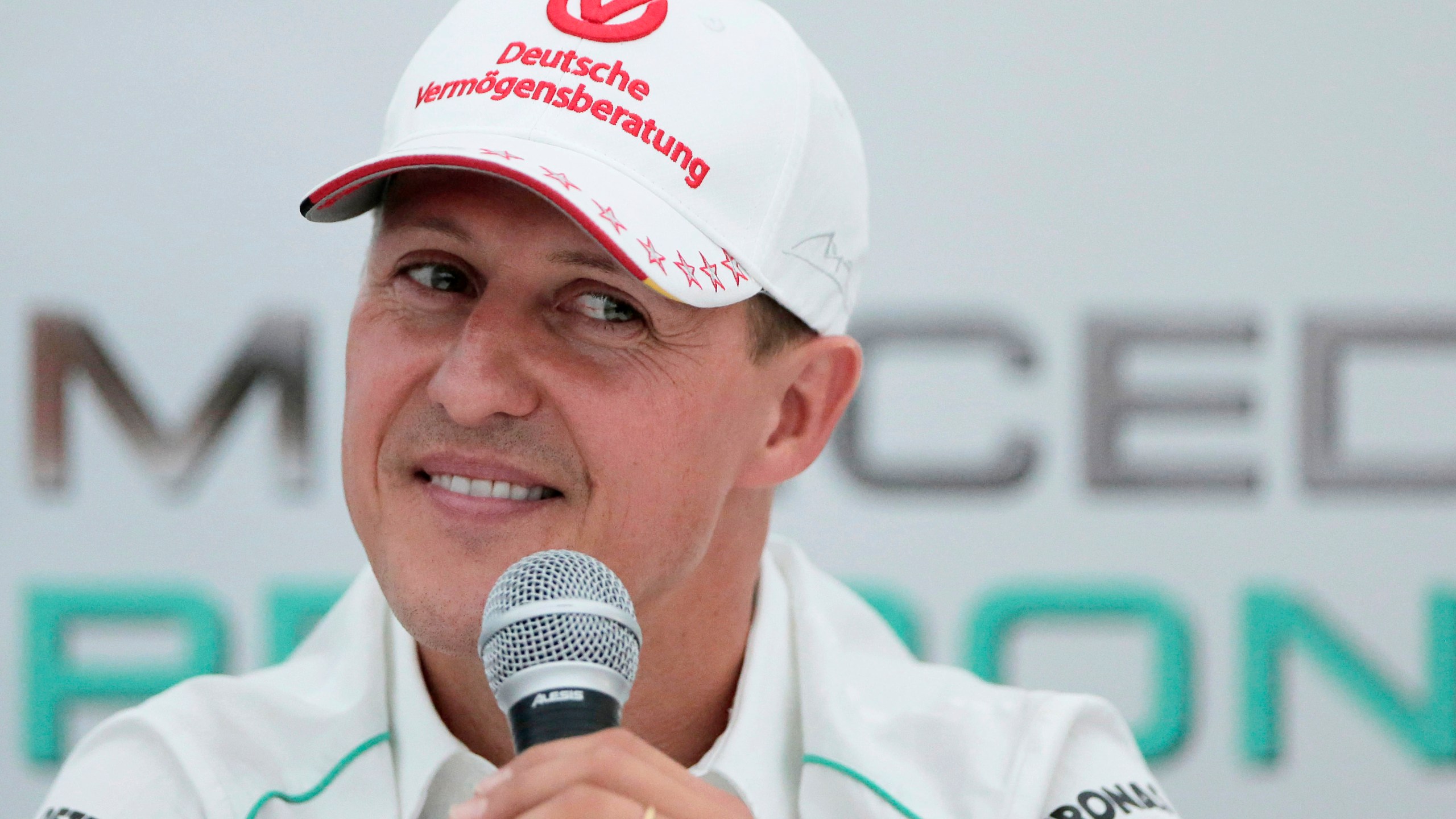 FILE - Michael Schumacher announces his retirement from Formula One during a press conference at the Suzuka Circuit venue for the Japanese Formula One Grand Prix in Suzuka, Japan, Oct. 4, 2012. German prosecutors say two men who allegedly tried blackmailing the family of former Formula 1 champion Michael Schumacher were detained earlier this month. Prosecutors in the western German city of Wuppertal said Monday the suspects told employees of the family that they were in possession of files that the family would not want to be published. (AP Photo/Itsuo Inouye, file)