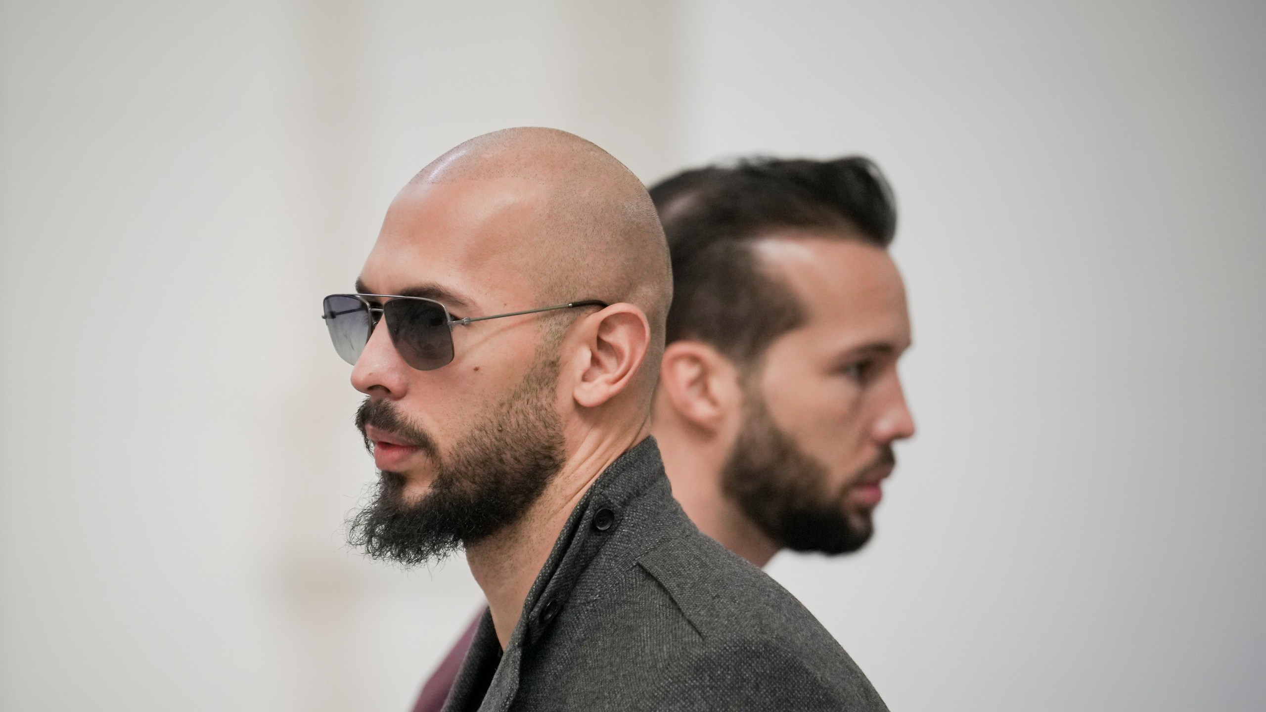 FILE - Andrew Tate, left, and his brother Tristan, right, wait inside the Court of Appeals building in Bucharest, Romania, Tuesday, Jan. 30, 2024. A court in Romania's capital on Friday, July 5, 2024 ruled that the online influencer Andrew Tate can leave Romanian territory providing he remains within the European Union, as he awaits trial on charges of human trafficking, rape and forming a criminal gang to sexually exploit women. (AP Photo/Vadim Ghirda, File)