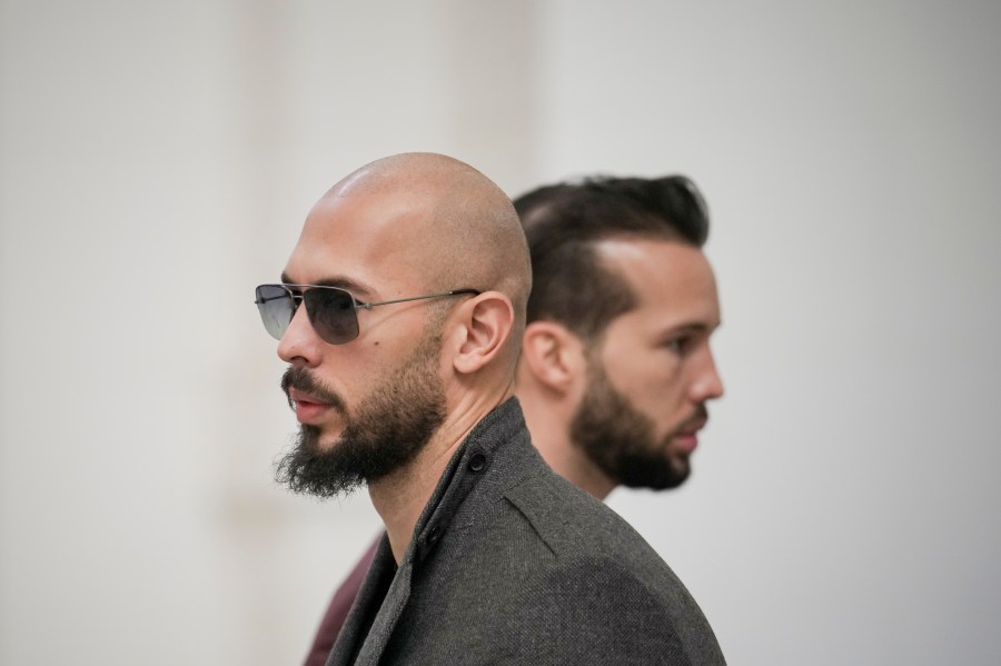 FILE - Andrew Tate, left, and his brother Tristan, right, wait inside the Court of Appeals building in Bucharest, Romania, Tuesday, Jan. 30, 2024. A court in Romania's capital on Friday, July 5, 2024 ruled that the online influencer Andrew Tate can leave Romanian territory providing he remains within the European Union, as he awaits trial on charges of human trafficking, rape and forming a criminal gang to sexually exploit women. (AP Photo/Vadim Ghirda, File)