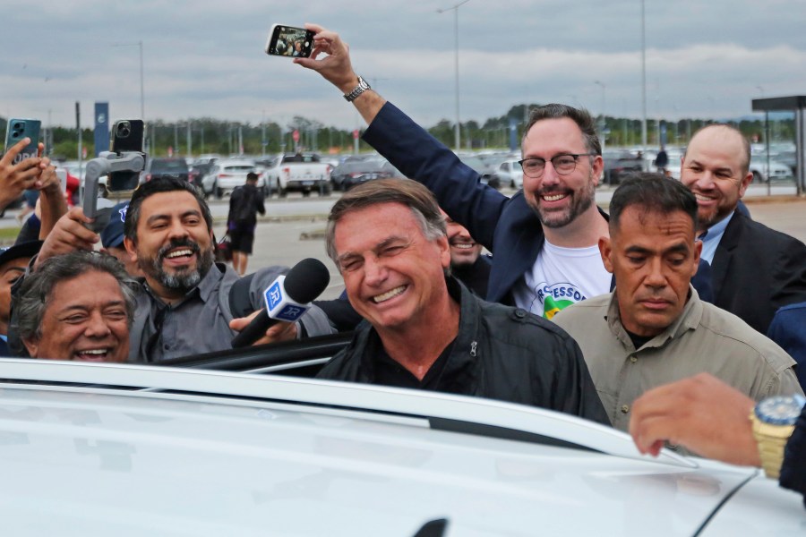 Former Brazilian President Jair Bolsonaro smiles as he prepares to depart the international airport in Florianopolis, Santa Catarina state, Brazil, Friday, July 5, 2024. Brazilian police have indicted Bolsonaro for money laundering and criminal association in connection with undeclared diamonds the far-right leader received from Saudi Arabia during his time in office, according to a source with knowledge of the accusations. (AP Photo/Heuler Andrey)