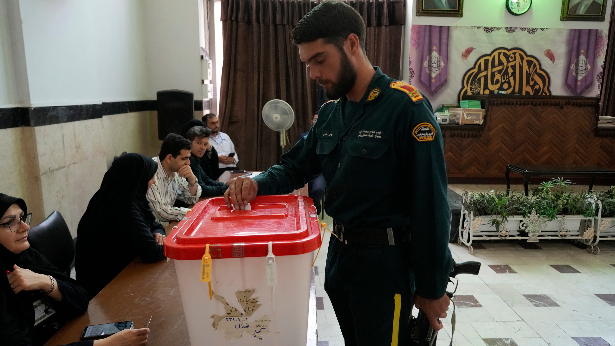 An Iranian policeman casts his vote for the presidential runoff election at a polling station in Tehran, Iran, Friday, July 5, 2024. Iranians began voting Friday in a runoff election to replace the late President Ebrahim Raisi, killed in a helicopter crash last month, as public apathy has become pervasive in the Islamic Republic after years of economic woes, mass protests and tensions in the Middle East. (AP Photo/Vahid Salemi)