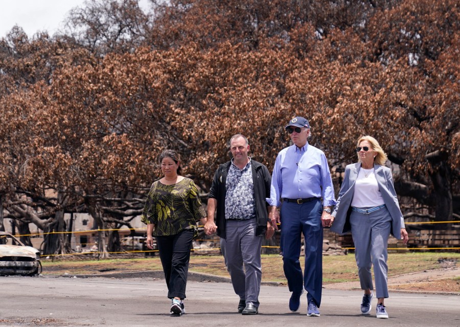 FILE - President Joe Biden and first lady Jill Biden walk with Hawaii Gov. Josh Green, second from left, and his wife Jaime Green as they pass the massive Banyan tree while visiting areas devastated by the Maui wildfires, Aug. 21, 2023, in Lahaina, Hawaii. Green, on Saturday, July 6, 2024, said Biden could decide within days whether to remain a candidate for re-election and that if the president drops out, he expects Vice President Kamala Harris to replace him at the top of the ticket. (AP Photo/Evan Vucci, File)