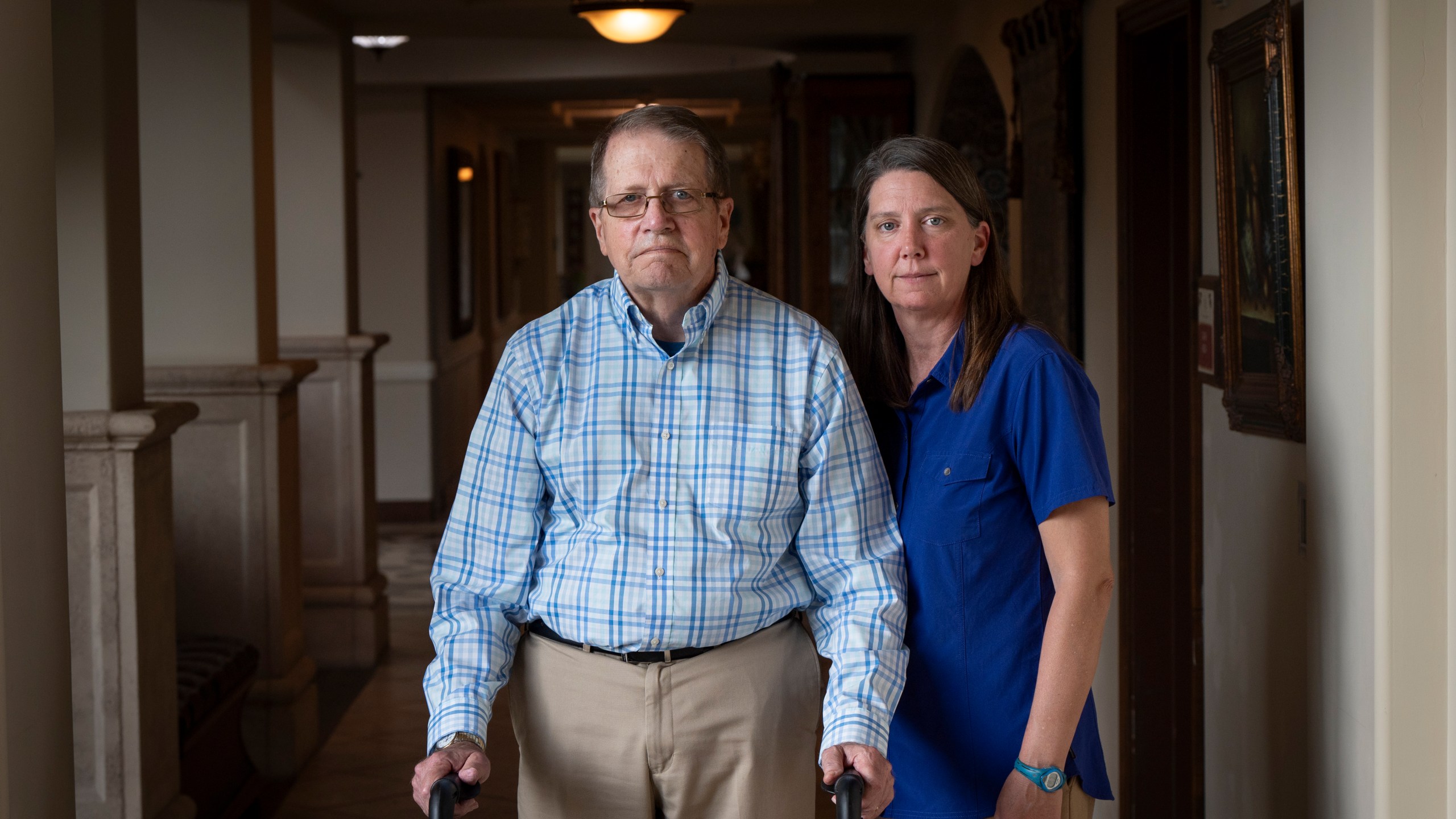 William Bortz, left, stands alongside his daughter, Ave Williams, at his senior living center, Friday, May 17, 2024, in San Diego. Bortz said criminals stole his family's nest egg of almost $700,000 in an elaborate scheme. Sophisticated overseas criminals are stealing tens of billions of dollars from Americans every year, a crime wave that's projected to get worse as the U.S. population ages and technology like AI makes it easier than ever to perpetrate fraud and get away with it. (AP Photo/Gregory Bull)