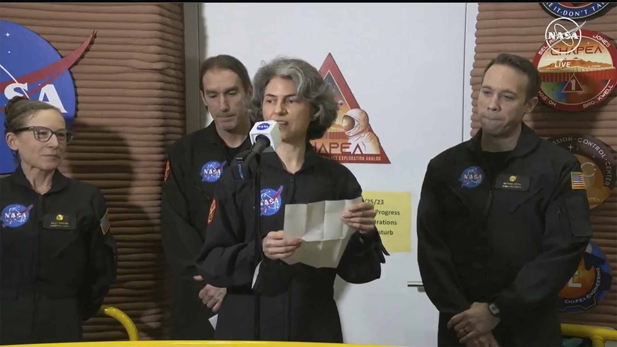 In this image made from video provided by NASA, Anca Selariu, a crew member of the first CHAPEA mission, speaks in front of other members, from left to right, Kelly Haston, Ross Brockwell, and Nathan Jones, Saturday, July 6, 2024, at Johnson Space Center in Houston, Texas. The crew of a NASA mission to Mars emerged from their craft after a yearlong voyage that never left Earth. The four volunteers crew members spent more than 12 months inside NASA's first simulated Mars environment at Johnson Space Center in Houston, coming out of the artificial alien environment Saturday. (NASA via AP)