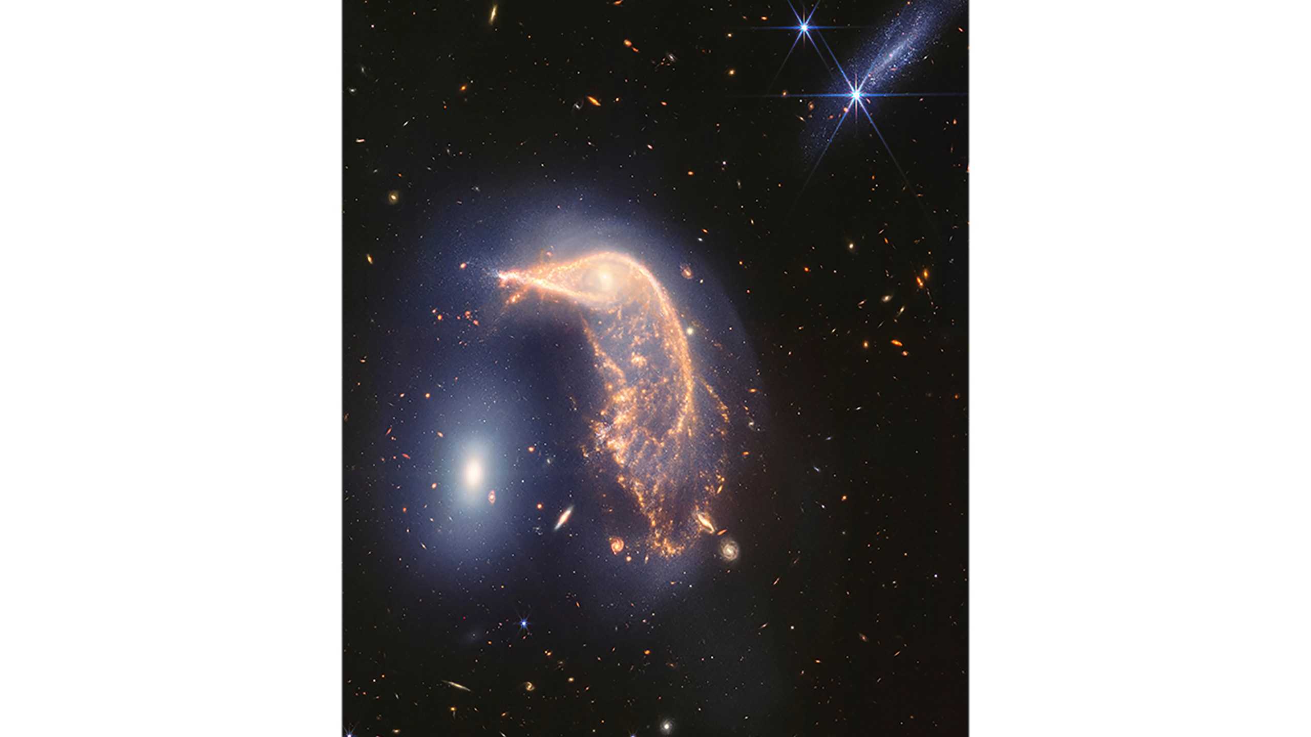 In this photo provided by NASA and the Space Telescope Science Institute, two interacting galaxies are captured by the Webb Space Telescope in the infrared. Scientists say the neighboring galaxies, nicknamed Penguin, right, and the Egg, left, have been tangled up for tens of millions of years. (NASA and Space Telescope Science Institute via AP)