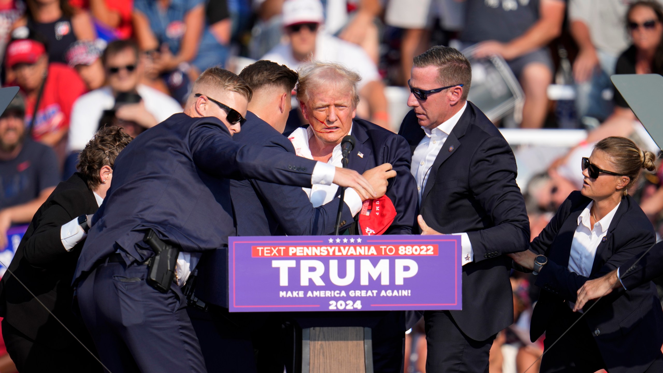 Republican presidential candidate former President Donald Trump is helped off the stage at a campaign event in Butler, Pa., on Saturday, July 13, 2024. (AP Photo/Gene J. Puskar)