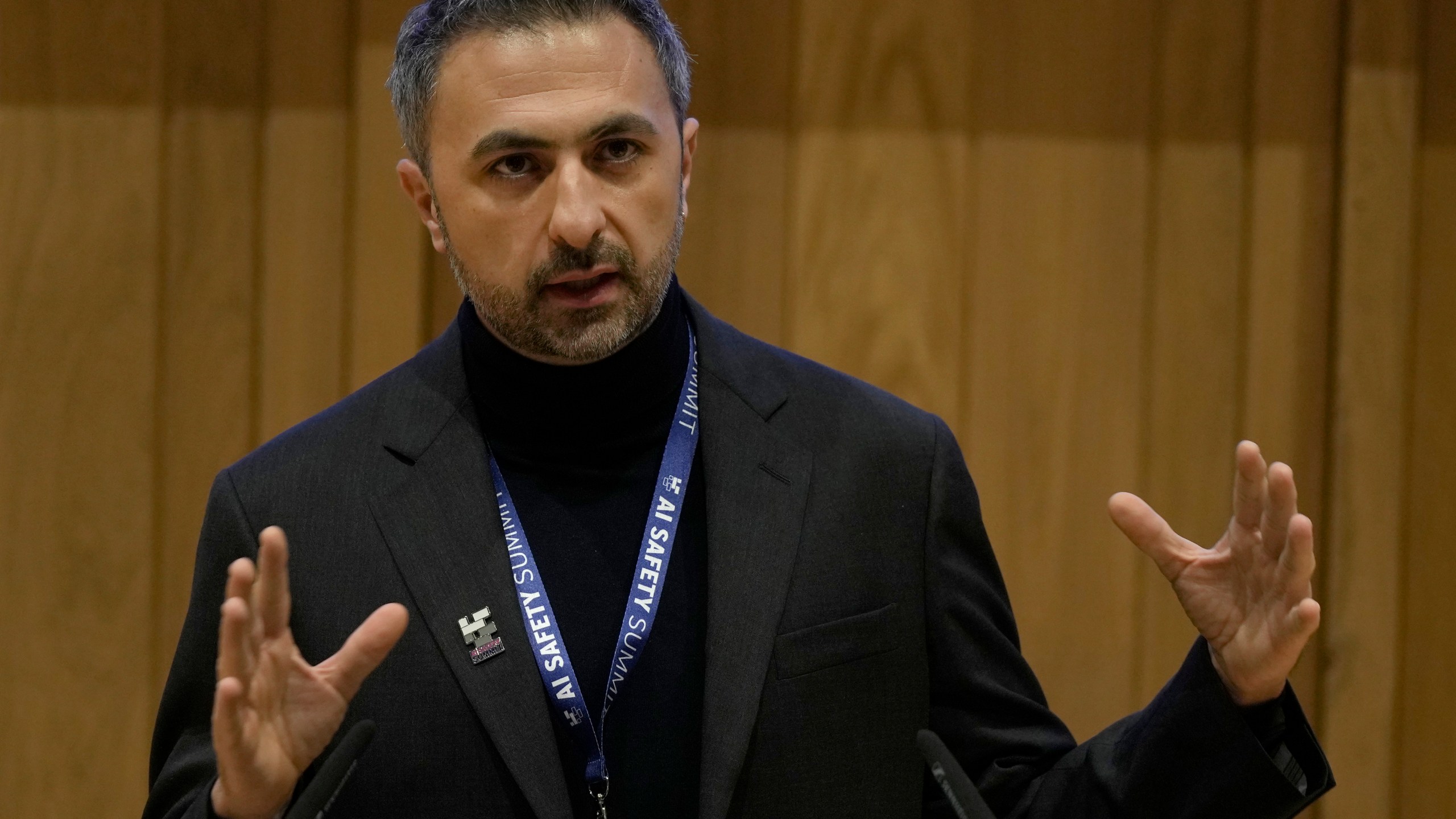 FILE - Mustafa Suleyman co founder and CEO of Inflection AI speaks to journalist during the AI Safety Summit in Bletchley Park, Milton Keynes, England, on Nov. 1, 2023. The Competition and Markets Authority said Tuesday, July 16, 2024 that its review of the hirings from Inflection AI turned up “sufficient information” to open an investigation. Microsoft hired Inflection's co-founder and CEO Mustafa Suleyman to head up its consumer artificial intelligence business, along with several top engineers and researchers. (AP Photo/Alastair Grant)