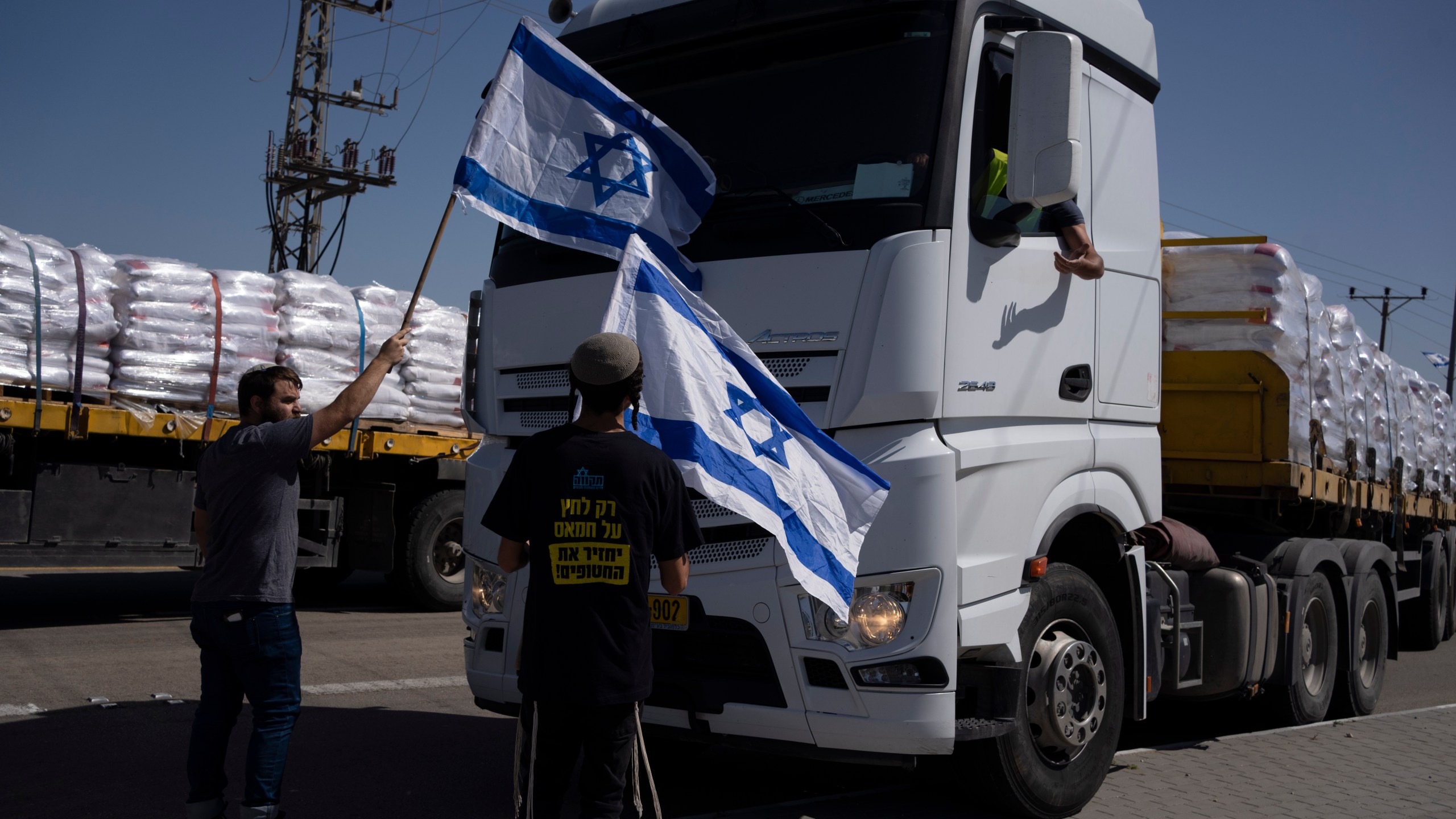 FILE - Activists stand in front of trucks carrying humanitarian aid as they try to stop them from entering the Gaza Strip in an area near the Kerem Shalom border crossing, southern Israel, Thursday, May 9, 2024. (AP Photo/Leo Correa, File)