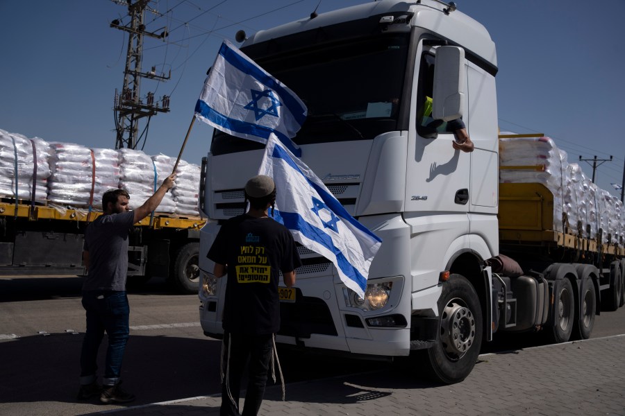 FILE - Activists stand in front of trucks carrying humanitarian aid as they try to stop them from entering the Gaza Strip in an area near the Kerem Shalom border crossing, southern Israel, Thursday, May 9, 2024. (AP Photo/Leo Correa, File)