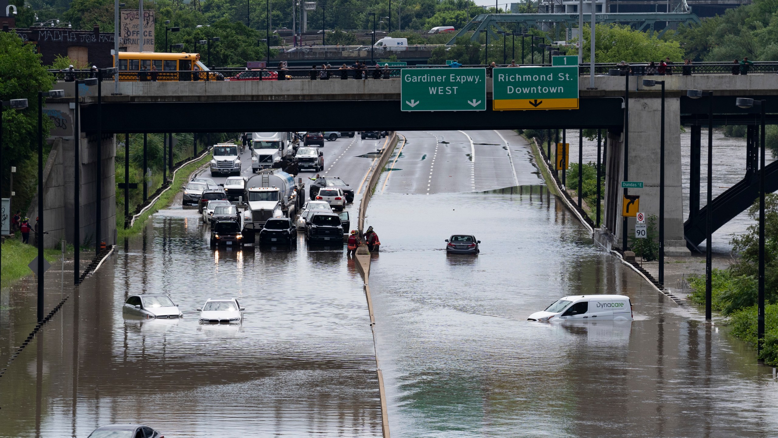 Cars are partially submerged in flood waters in the Don Valley following heavy rain in Toronto, on Tuesday, July 16 2024. (Arlyn McAdorey/The Canadian Press via AP)