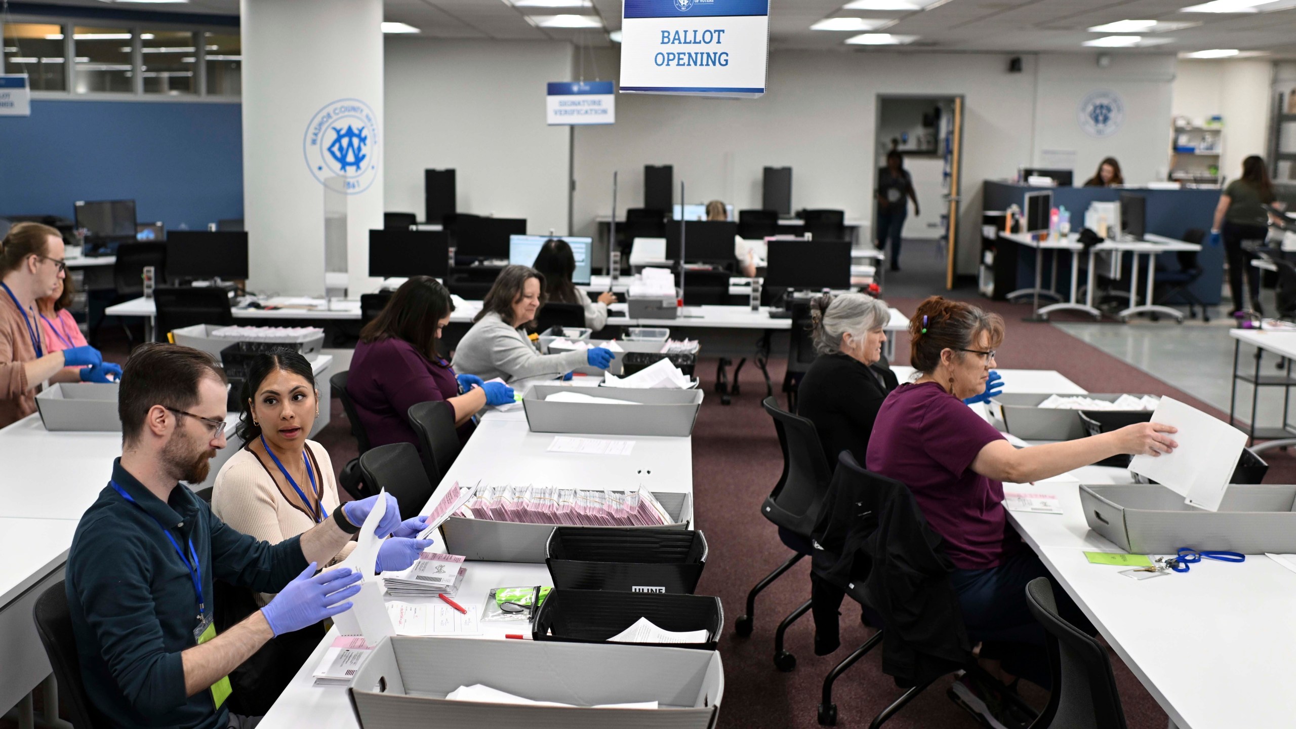 FILE - County employees open ballots in the ballot opening area of the mail ballot processing room at the Washoe County Registrar of Voters office in Reno, Nev., June 3, 2024. Commissioners in Nevada's second most populous county certified the results of two local recounts on Tuesday, July 16, reversing course on a controversial vote against certification that spurred legal action and put Washoe County in unchartered legal territory. (AP Photo/Andy Barron, File)