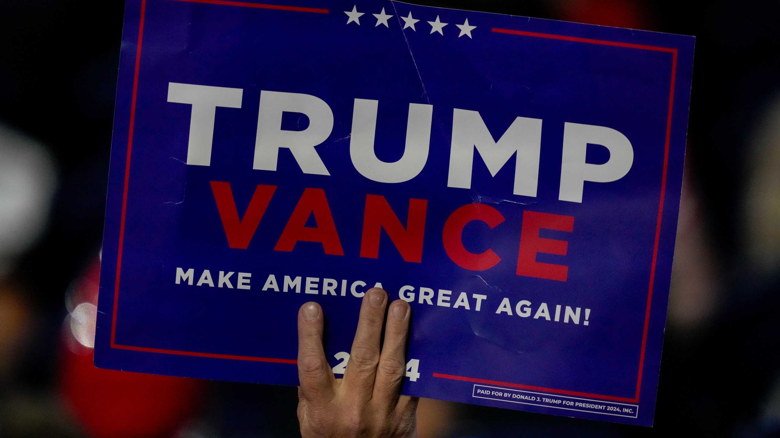 A suppoerter holds a sign during the Republican National Convention Tuesday, July 16, 2024, in Milwaukee. (AP Photo/Charles Rex Arbogast)