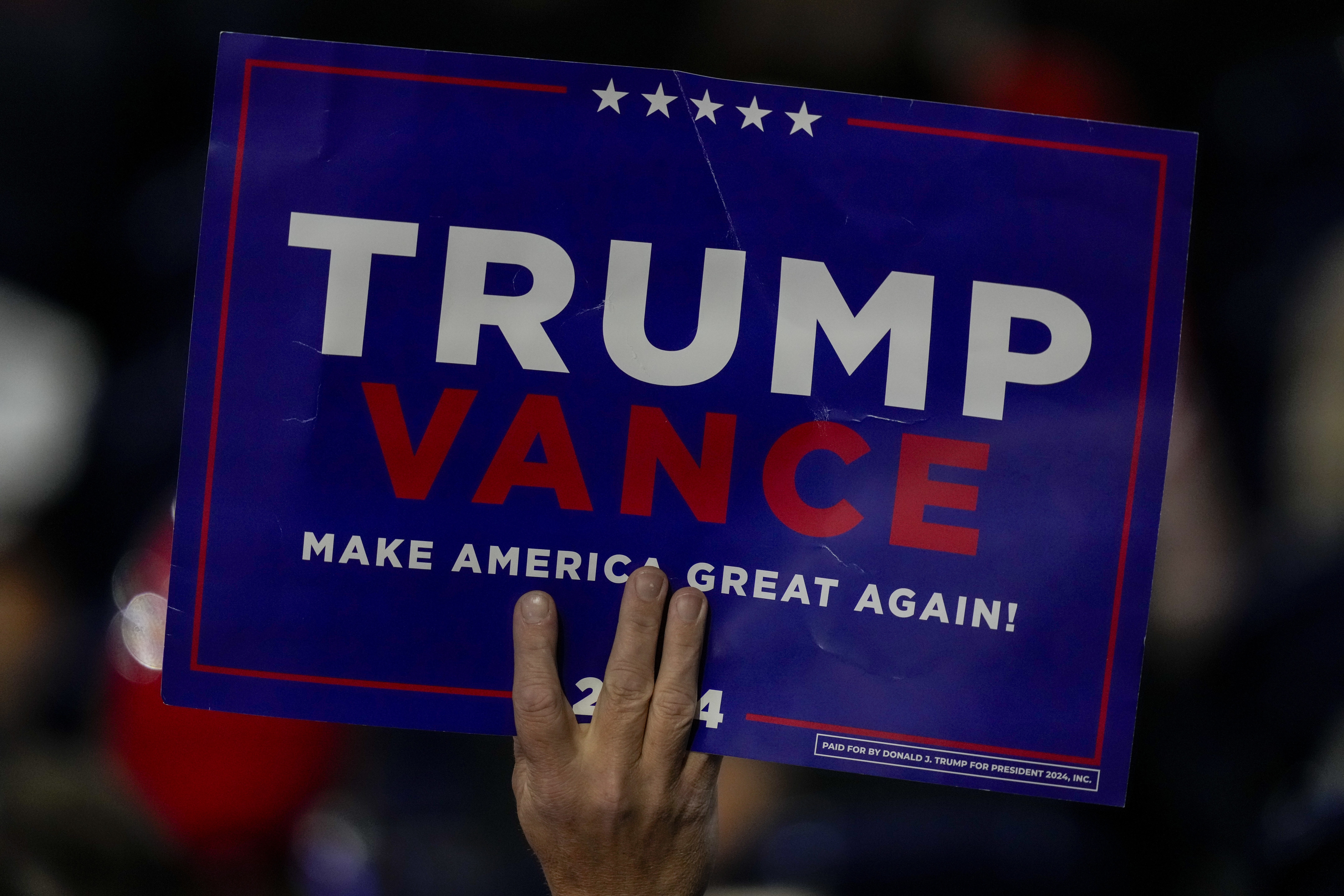 A suppoerter holds a sign during the Republican National Convention Tuesday, July 16, 2024, in Milwaukee. (AP Photo/Charles Rex Arbogast)