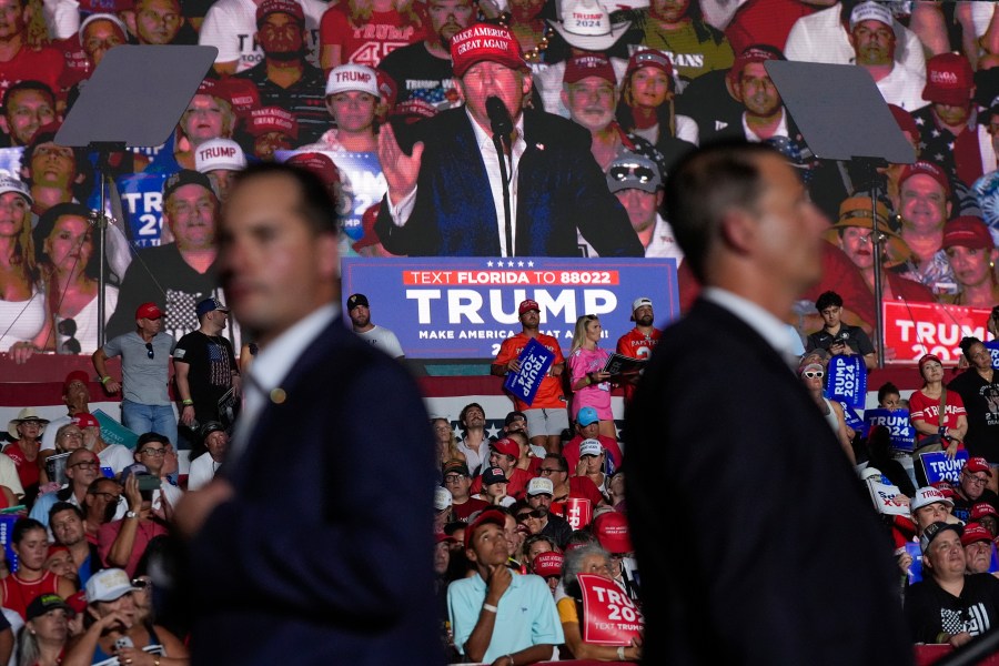 U.S. Secret Service agents watch as an image of Republican presidential candidate former President Donald Trump is shown on a screen at a campaign rally at Trump National Doral Miami, Tuesday, July 9, 2024, in Doral, Fla. (AP Photo/Rebecca Blackwell)