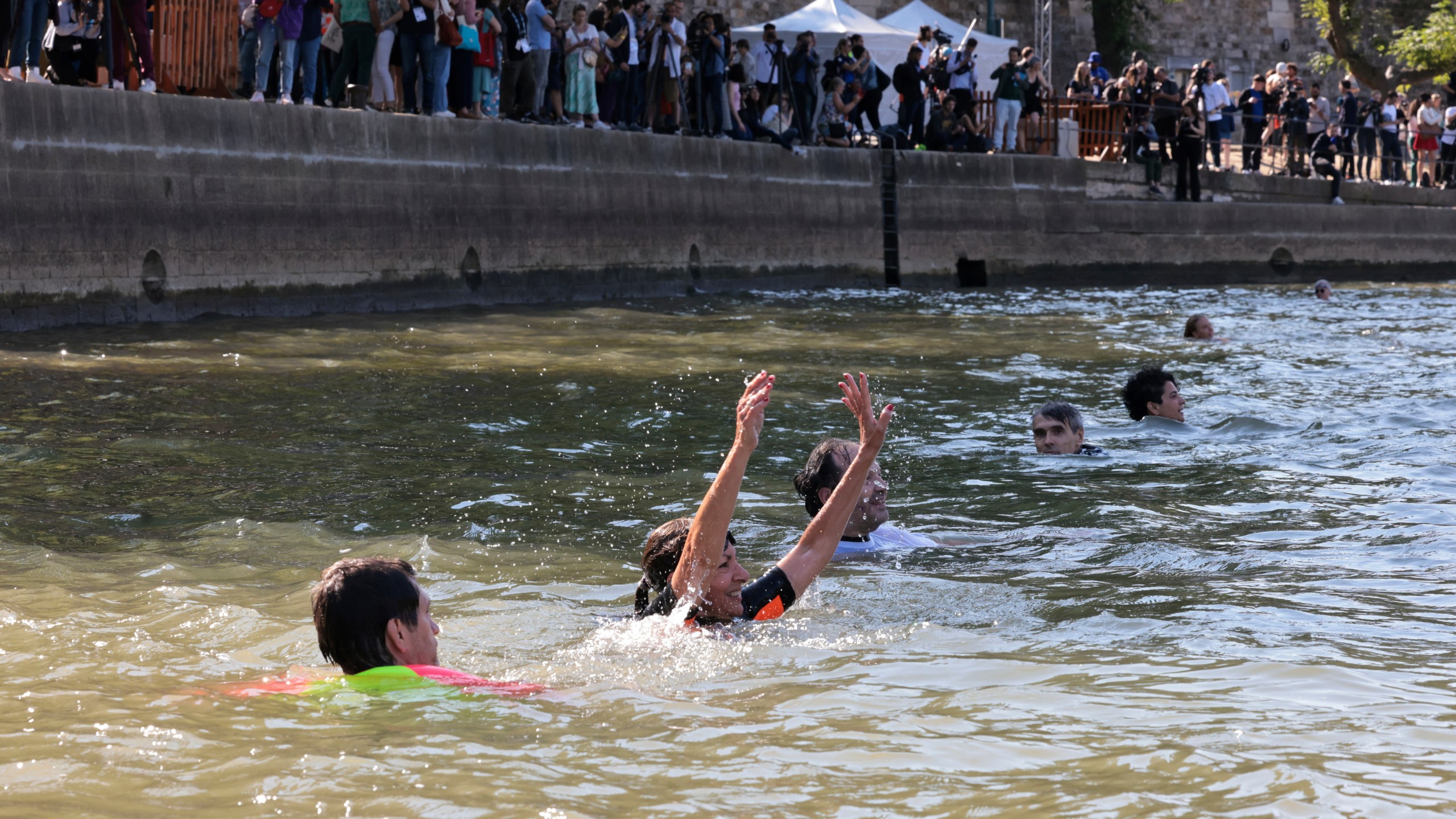 Paris Mayor Anne Hidalgo, center, swims in the Seine river, Wednesday, July 17, 2024 in Paris. After months of anticipation, Paris Mayor Anne Hidalgo took a dip in the Seine River on Wednesday, fulfilling a promise she made months ago to show the river is clean enough to host open-swimming competitions during the 2024 Olympics — and the opening ceremony on the river nine days away.(Joel Saget, Pool via AP)