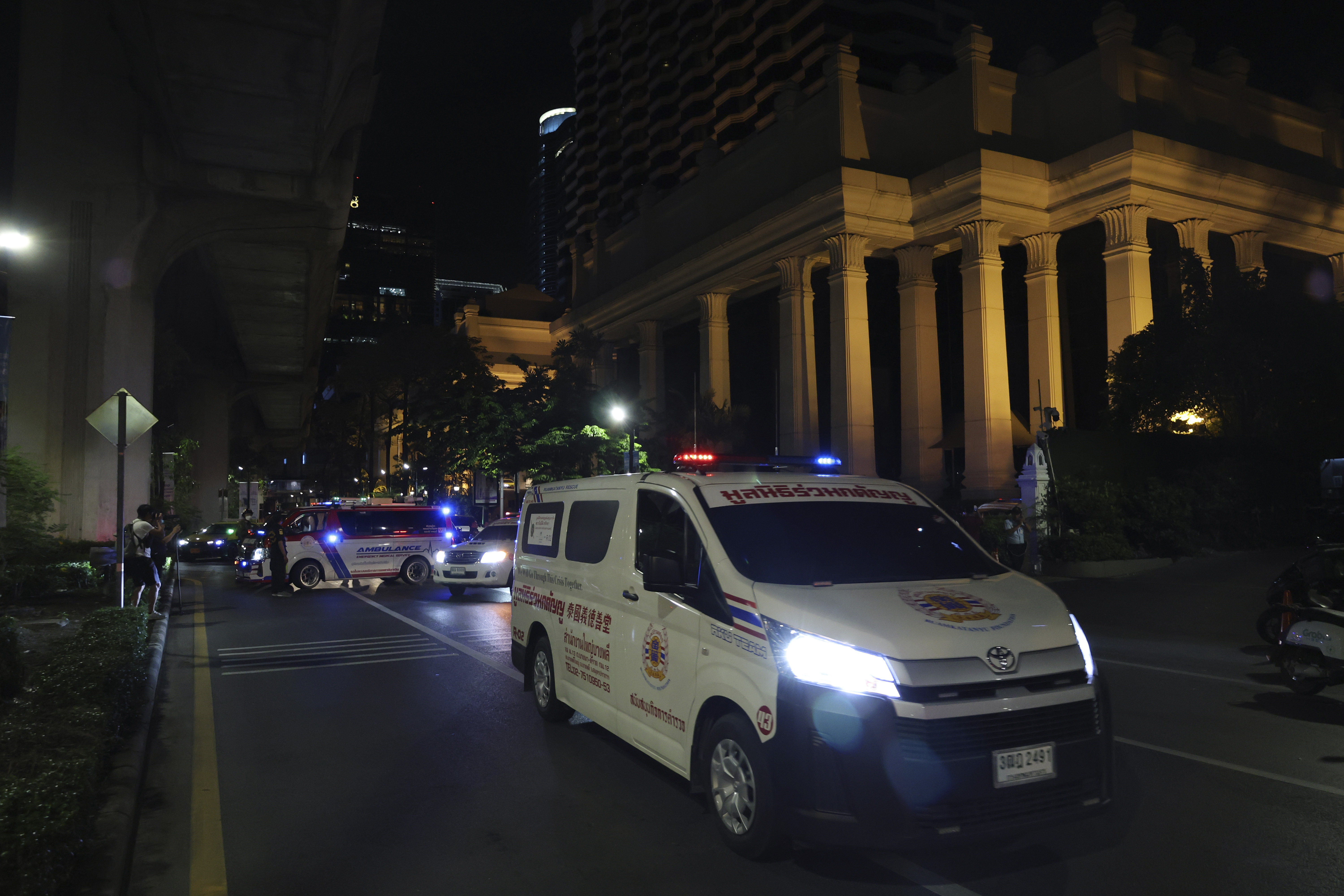 An ambulance sits outside the Grand Hyatt Erawan Hotel to Chulalongkorn hospital in Bangkok, Thailand, Tuesday, July 16, 2024. Police say the bodies of six people were found in the luxury hotel in downtown Bangkok. (AP Photo/Chatkla Samnaingjam)