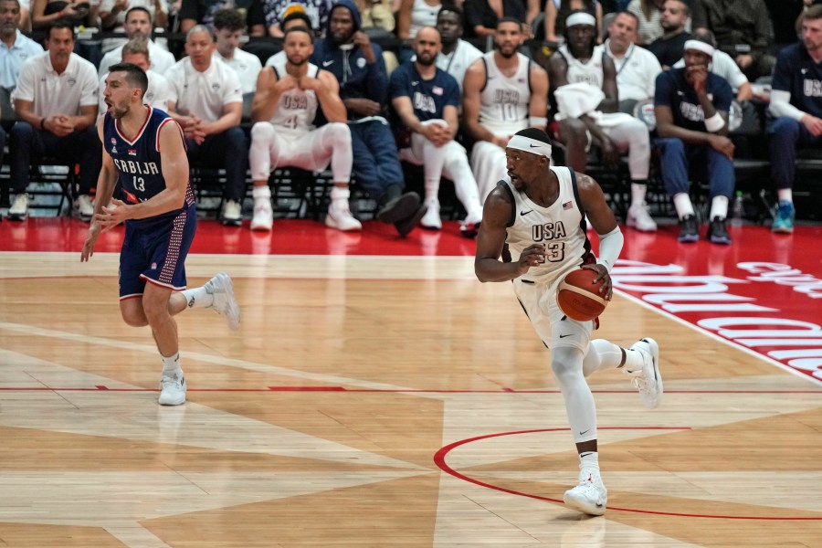 United States' Bam Adebayo, right, drives to the basket during an exhibition basketball match between Serbia and the United States at the USA Basketball Showcase, ahead of the 2024 Paris Olympic basketball tournament, in Abu Dhabi, United Arab Emirates, Wednesday, July 17, 2024. (AP Photo/Altaf Qadri)