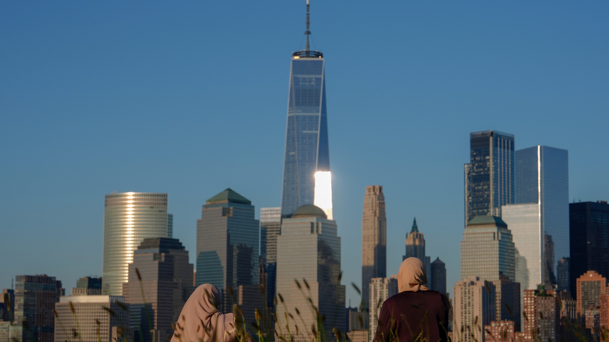 FILE - People look out at the New York City skyline at sunset, Sunday, June 16, 2024, in Jersey City, N.J. A meteor streaked across the New York City skyline before disintegrating over nearby New Jersey, according to NASA. William Cooke, the head of the space agency's Meteoroid Environments Office, said the fireball was first sighted at an altitude of 51 miles (82 kilometers) above Manhattan at around 11:17 a.m. Tuesday, Juky 14, 2024. (AP Photo/Julia Nikhinson, File)