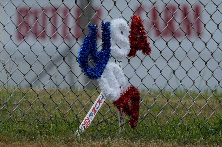 A memorial rest along a fence outside the Butler Farm Show in Butler, Pa., Wednesday, July 17, 2024, the site where firefighter Corey Comperatore died after a gunman opened fire at the rally. (AP Photo/Eric Gay)