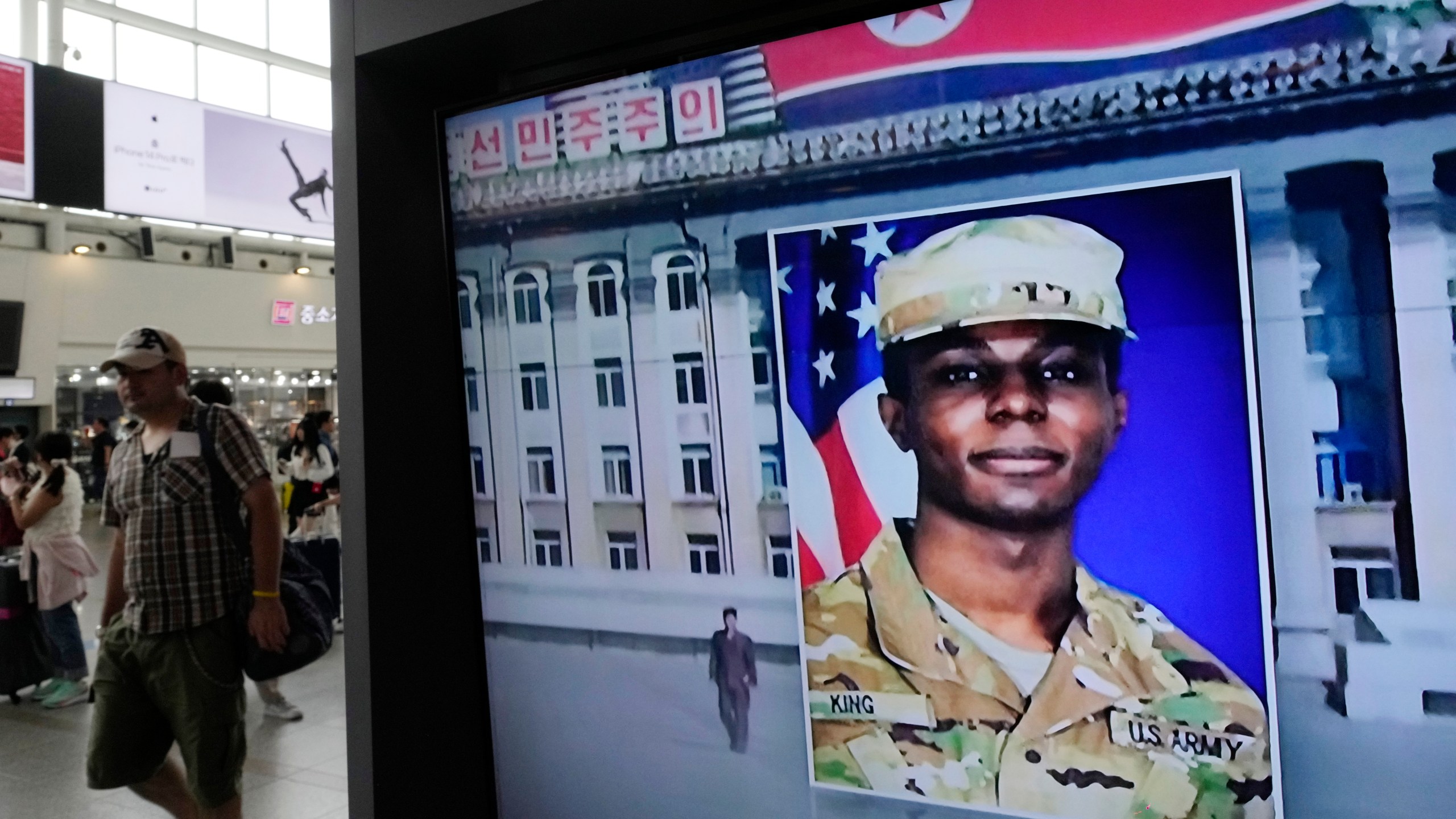 FILE - A TV screen shows a file image of American soldier Travis King during a news program at the Seoul Railway Station in Seoul, South Korea on Aug. 16, 2023. A lawyer for Army Pvt. King, who fled to North Korea and was later charged with desertion and possessing sexual images of a child, says he's in negotiations with military prosecutors to resolve the case against his client. King had been scheduled for a preliminary hearing Tuesday in Fort Bliss, Texas. (AP Photo/Ahn Young-joon, File)