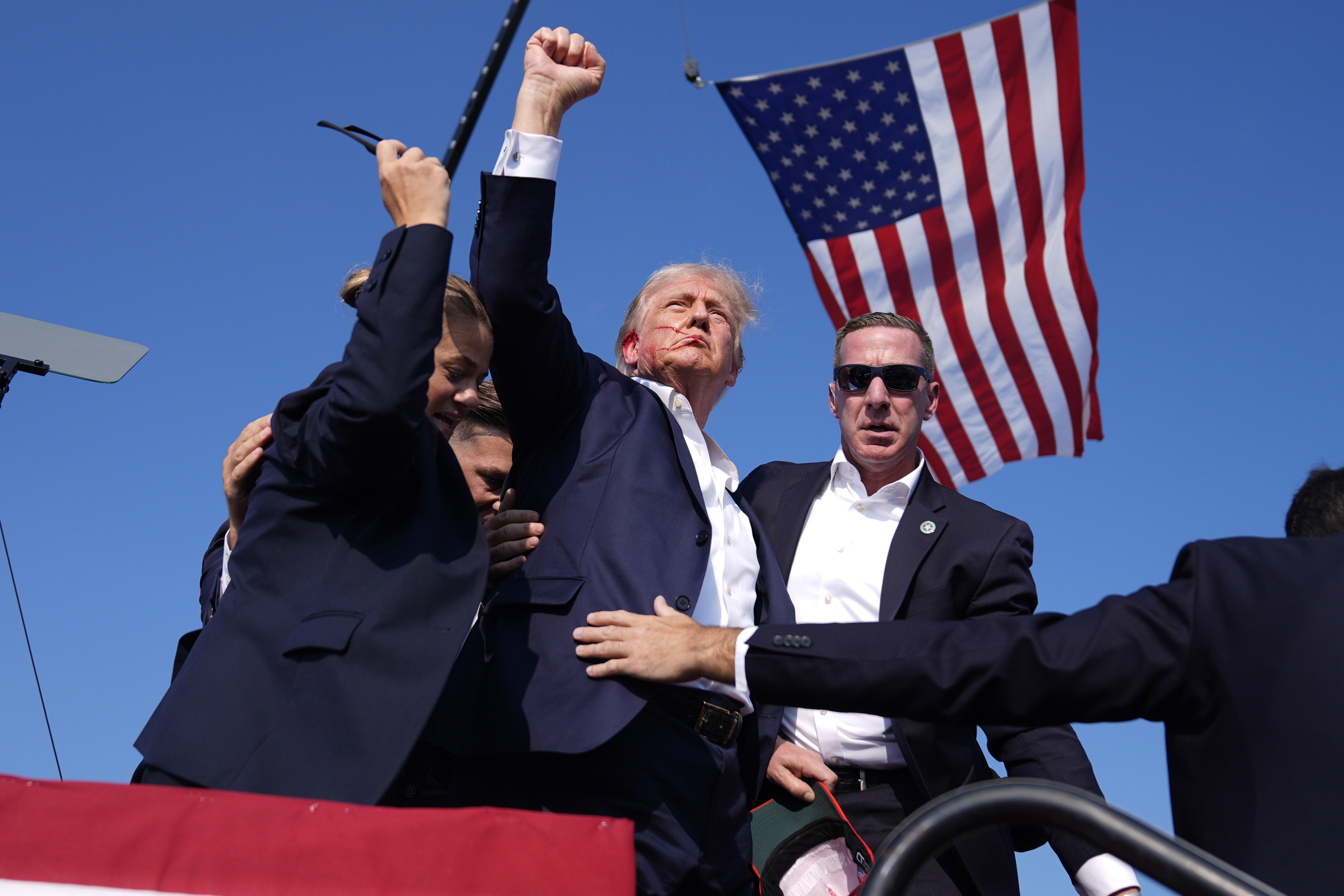 FILE - Republican presidential candidate former President Donald Trump gestures as he is surrounded by U.S. Secret Service agents as he leaves the stage at a campaign rally, July 13, 2024, in Butler, Pa. (AP Photo/Evan Vucci, File)