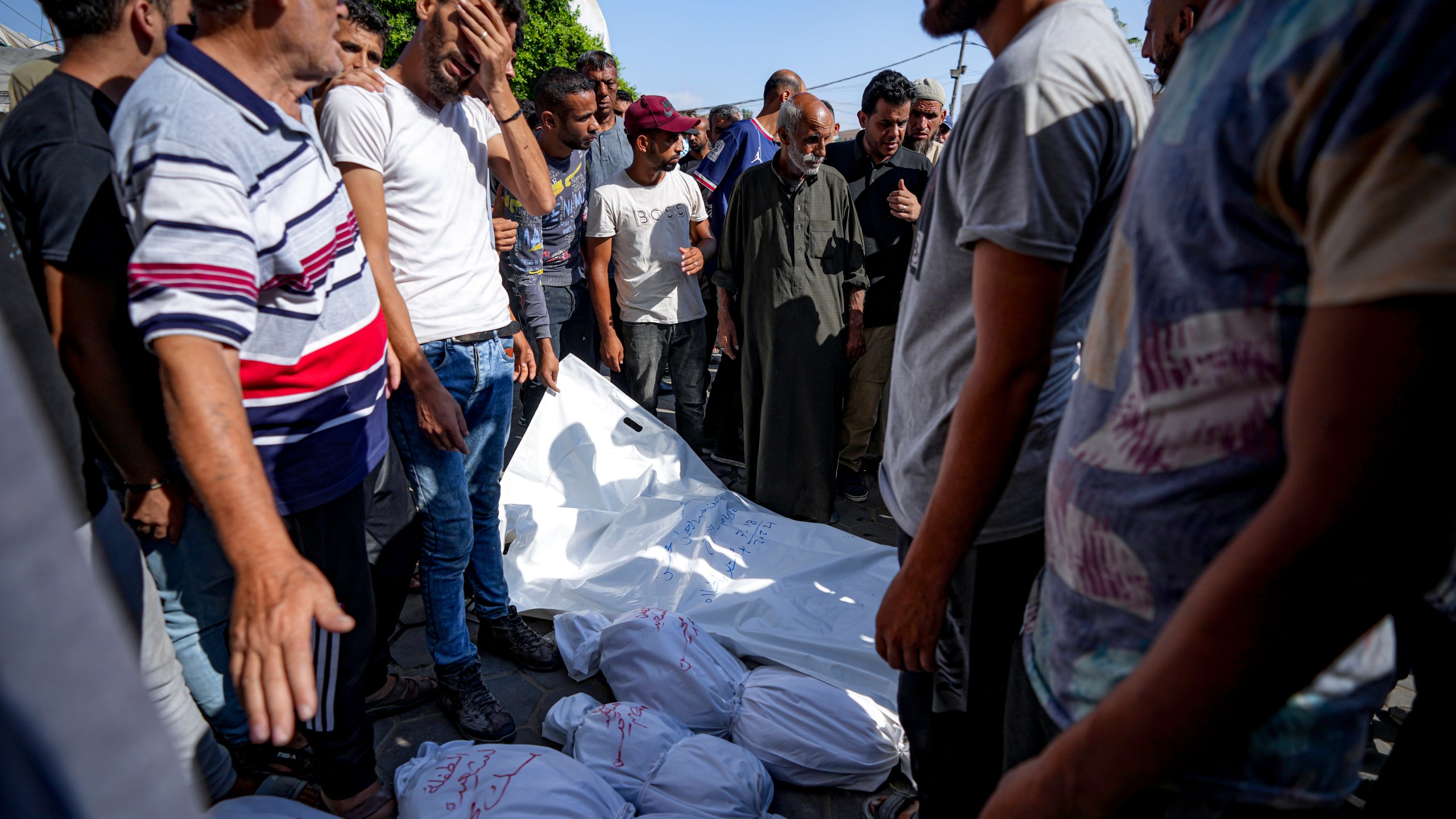 Palestinians gather near the bodies of their relatives killed in the Israeli bombardment of the Gaza Strip, at a hospital in Deir al-Balah, Thursday, July 18, 2024. (AP Photo/Abdel Kareem Hana)