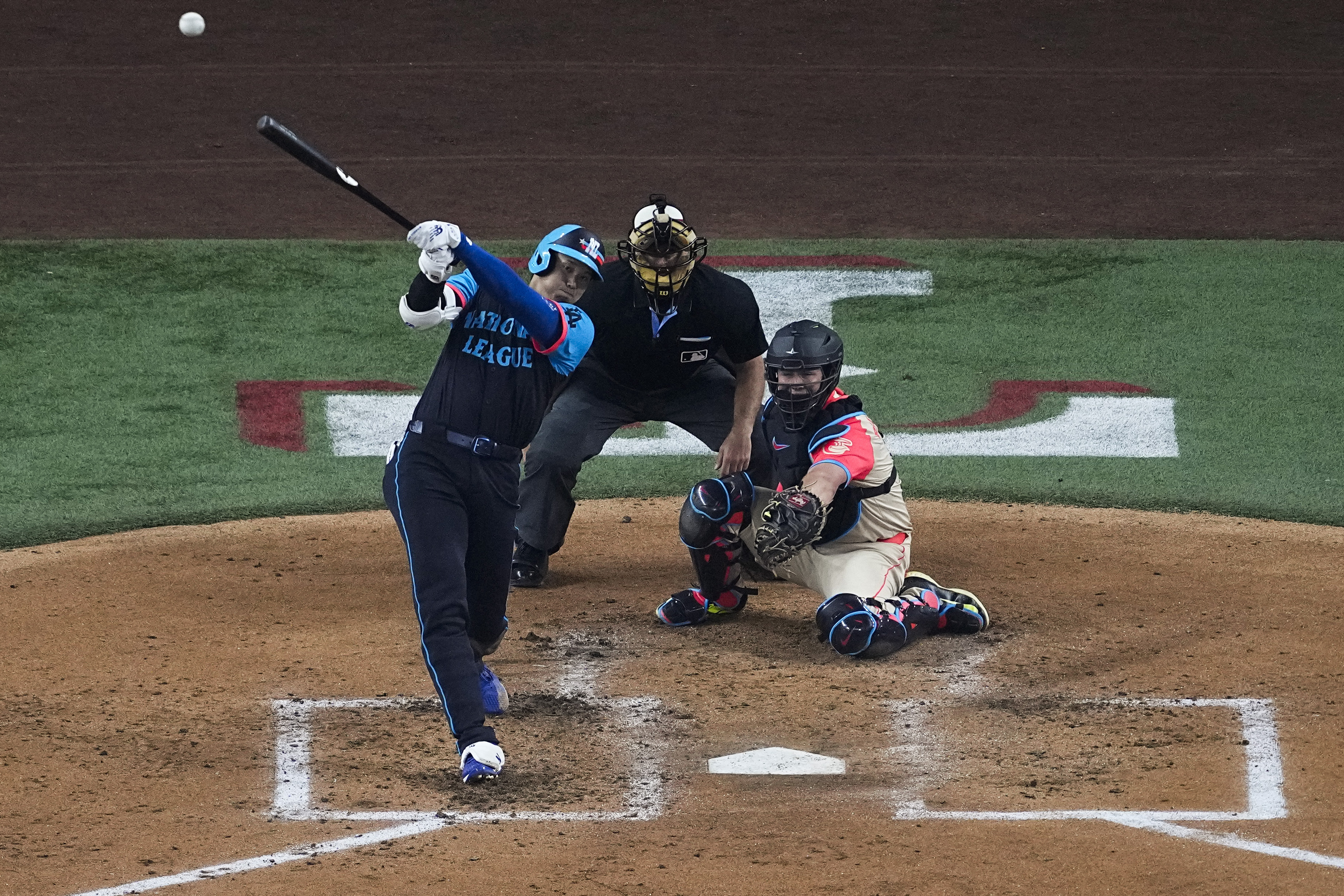 National League's Shohei Ohtani, of the Los Angeles Dodgers, hits a home run during the third inning of the MLB All-Star baseball game, Tuesday, July 16, 2024, in Arlington, Texas. Jurickson Profar, of the San Diego Padres, and Ketel Marte, of the Arizona Diamondbacks, also scored. (AP Photo/Tony Gutierrez)