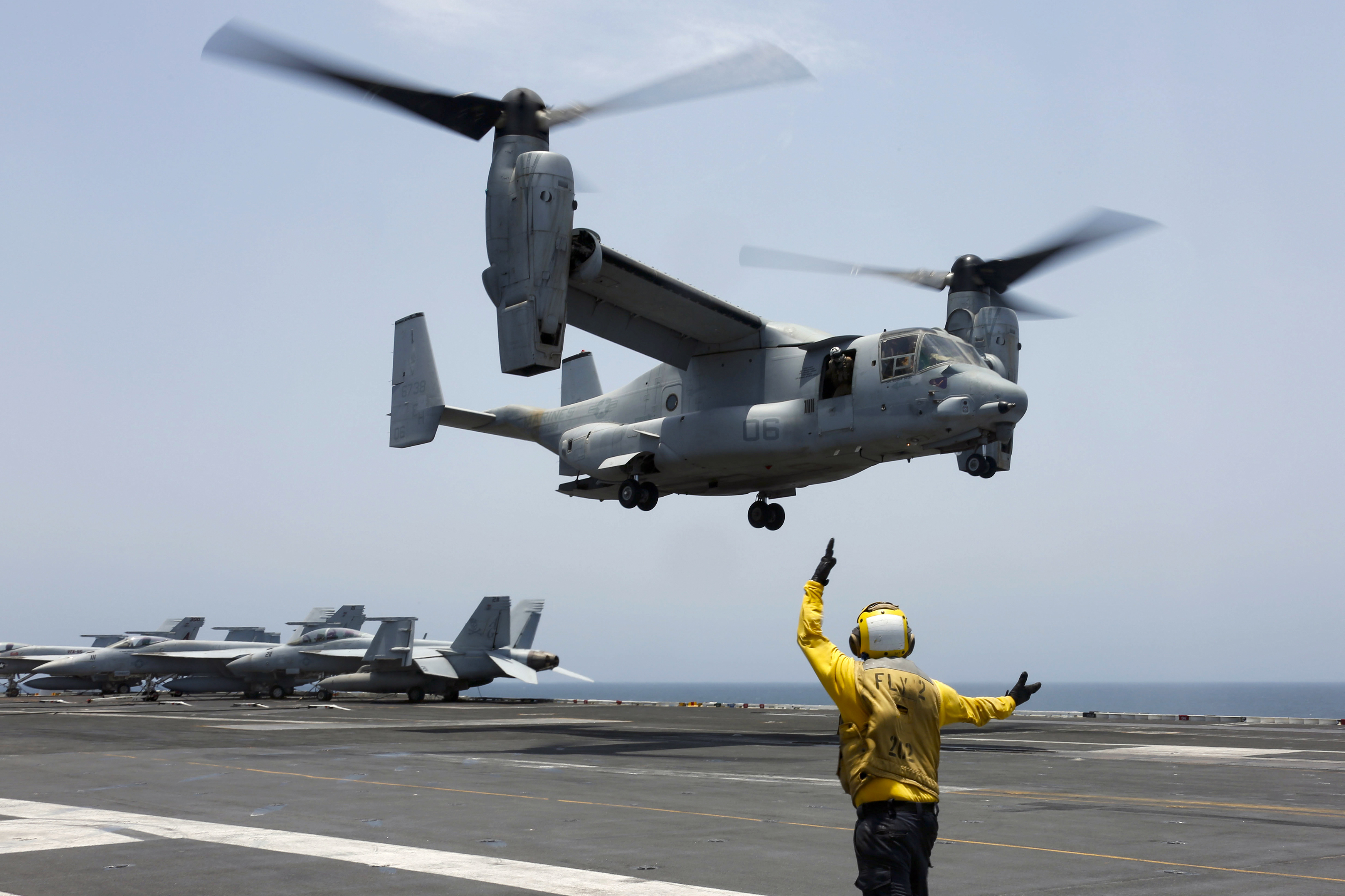 FILE - In this image provided by the U.S. Navy, Aviation Boatswain's Mate 2nd Class Nicholas Hawkins signals an MV-22 Osprey to land on the flight deck of the USS Abraham Lincoln in the Arabian Sea on May 17, 2019. Three Massachusetts lawmakers are pressing Defense Secretary Lloyd Austin to extend flight restrictions on the V-22 Osprey until the military can identify the root causes of multiple recent accidents. Democratic Sens. Elizabeth Warren and Ed Markey and Rep. Lloyd Neal in a letter to Austin on Thursday call the decision to return Ospreys to limited flight status misguided. (Mass Communication Specialist 3rd Class Amber Smalley/U.S. Navy via AP)