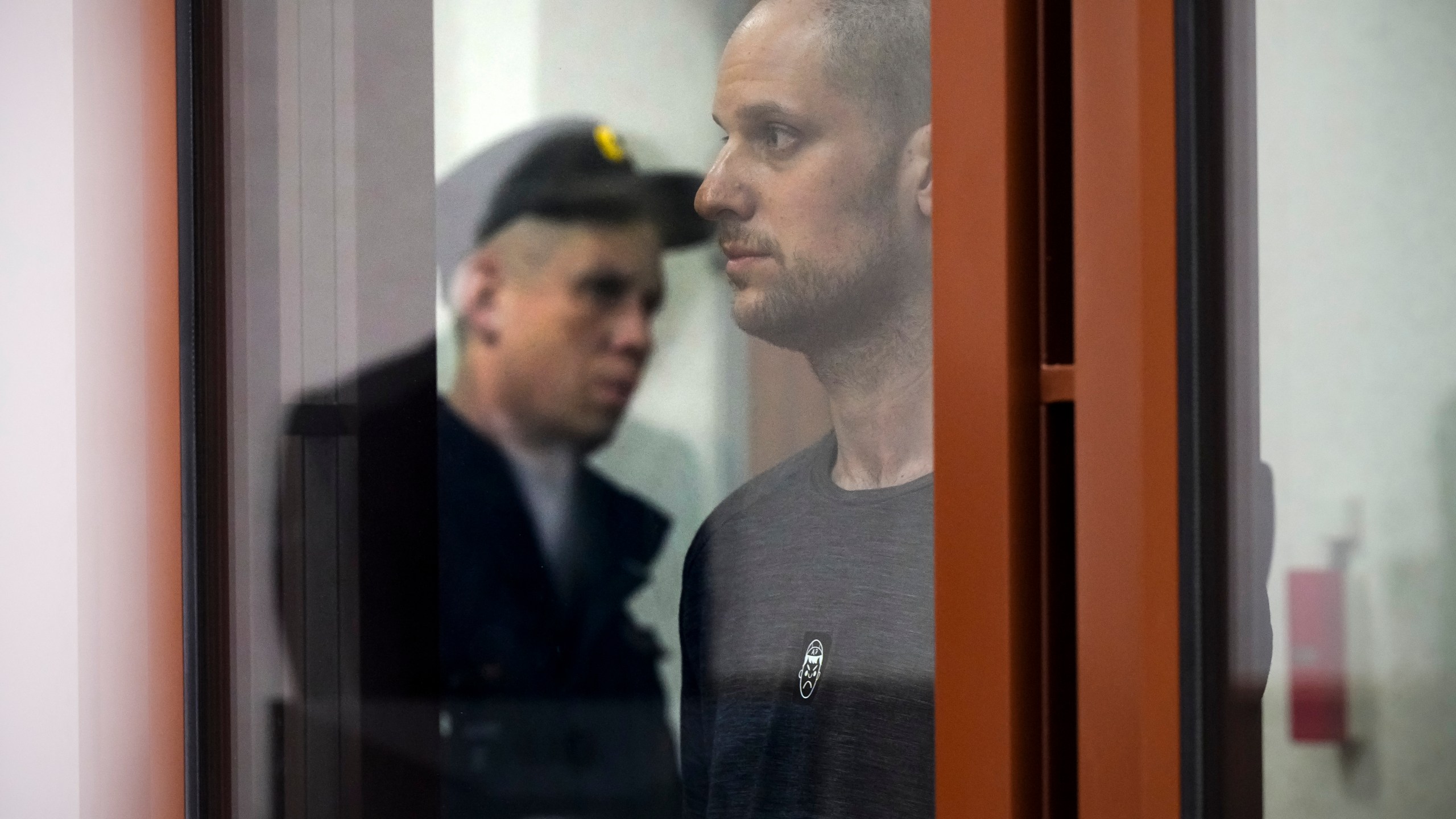 Wall Street Journal reporter Evan Gershkovich stands listening to the verdict in a glass cage of a courtroom inside the building of "Palace of justice," in Yekaterinburg, Russia, on Friday, July 19, 2024. A Russian court convicted Gershkovich on espionage charges that his employer and the U.S. have rejected as fabricated. He was sentenced to 16 years in prison after a secretive and rapid trial in the country's highly politicized legal system. (AP Photo/Dmitri Lovetsky)