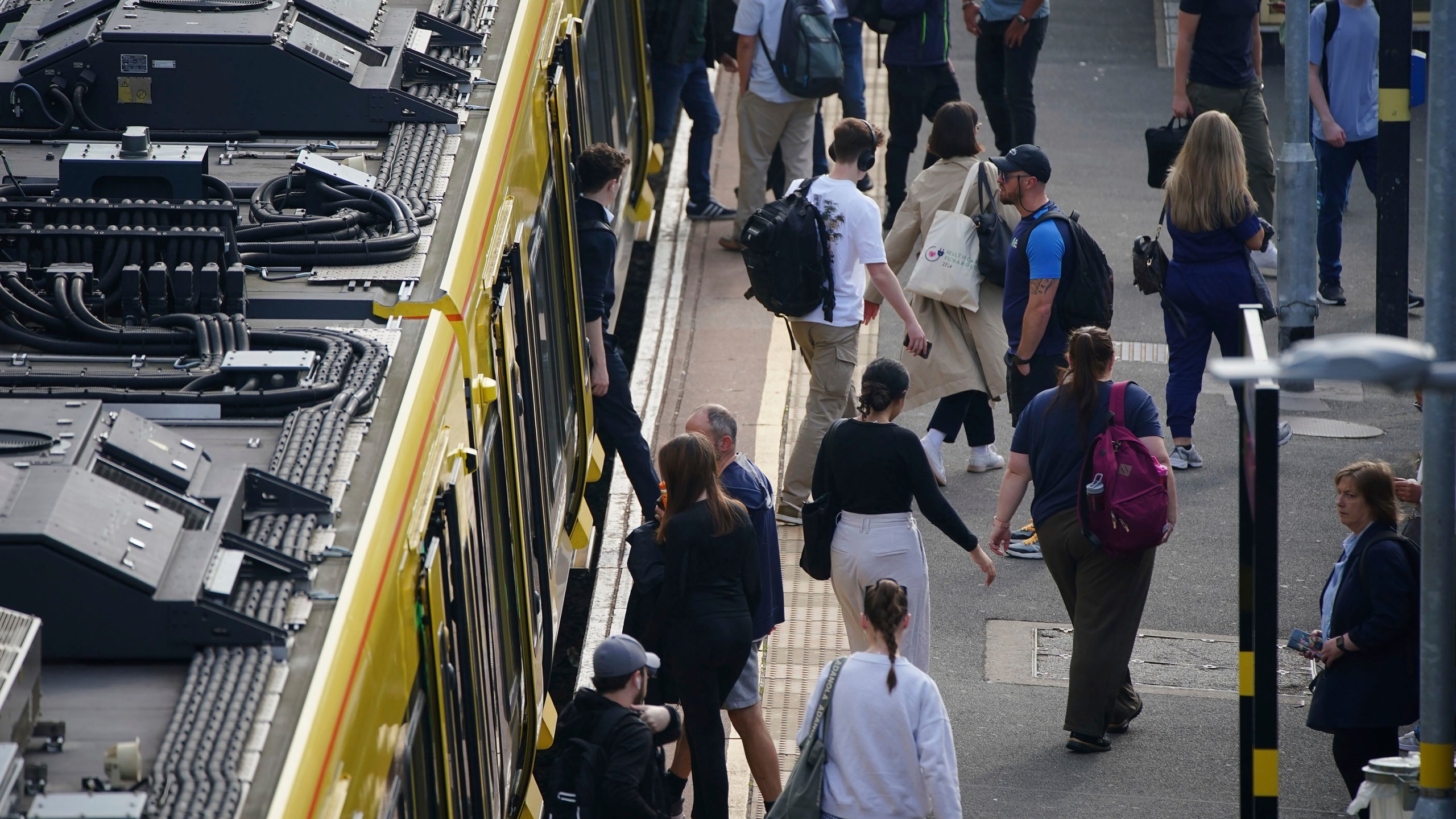 Commuter disembark a Great Northern railway train at Hunt's Cross station in Liverpool, England, amid reports of widespread IT outages affecting airlines, broadcasters and banks, Friday, July 19, 2024. (Peter Byrne/PA via AP)