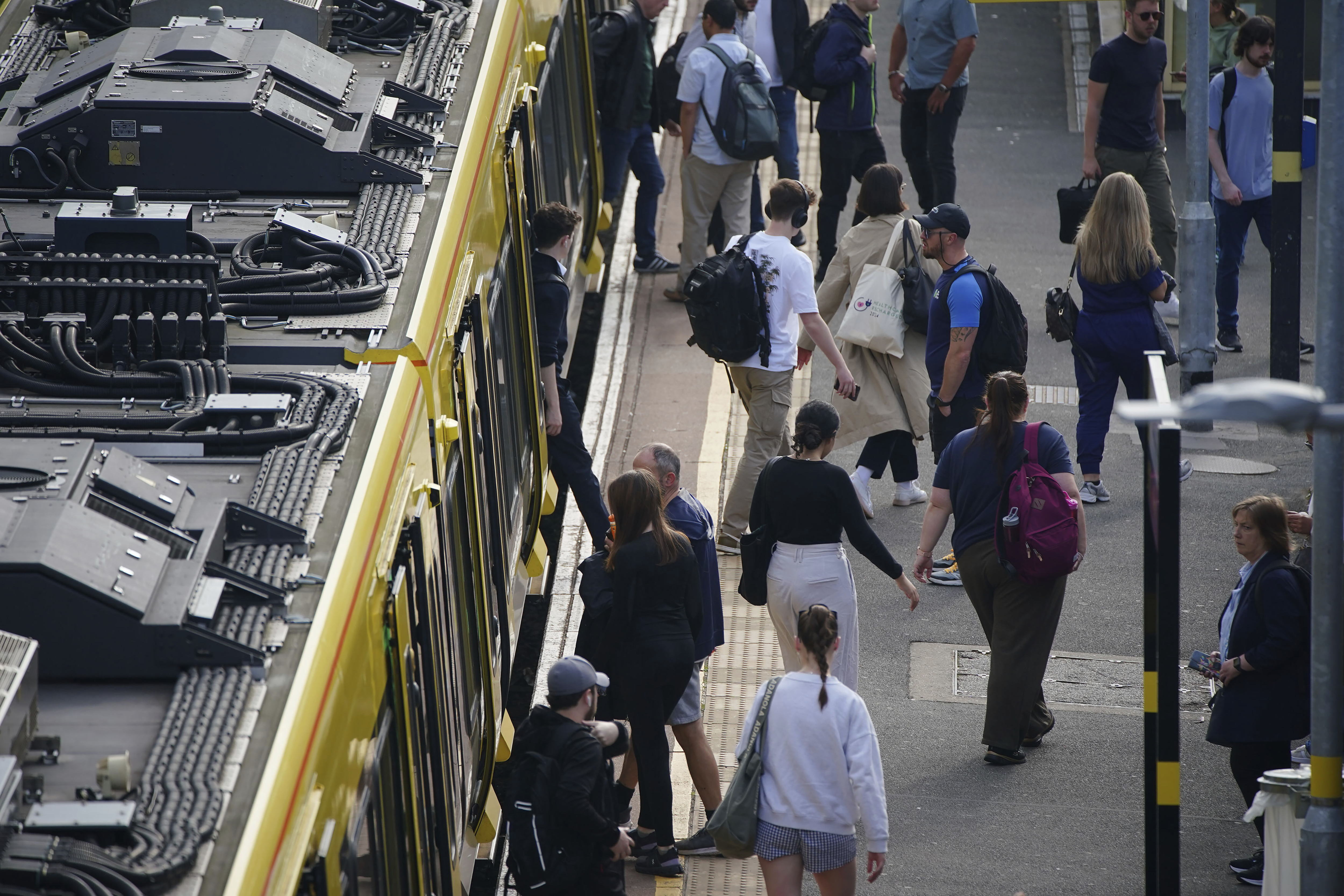 Commuter disembark a Great Northern railway train at Hunt's Cross station in Liverpool, England, amid reports of widespread IT outages affecting airlines, broadcasters and banks, Friday, July 19, 2024. (Peter Byrne/PA via AP)