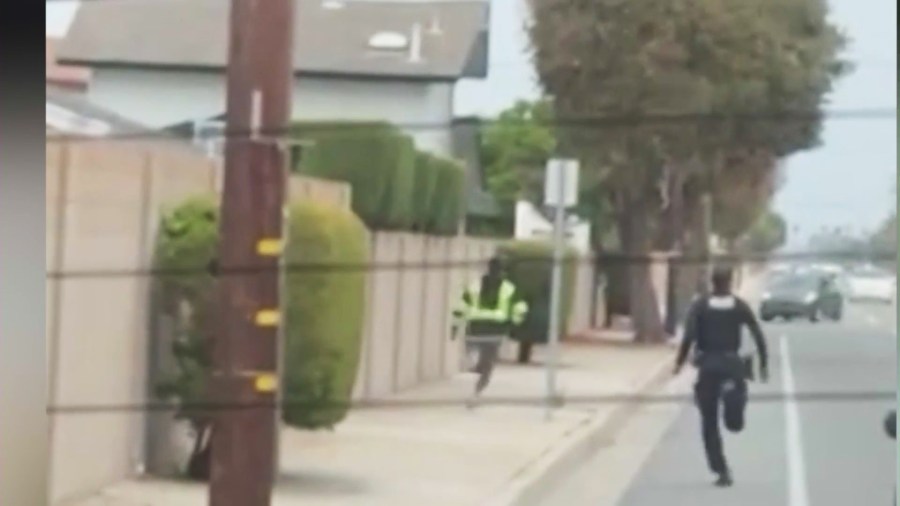 A police officer chasing after a burglary suspect in Fountain Valley on July 11, 2024.