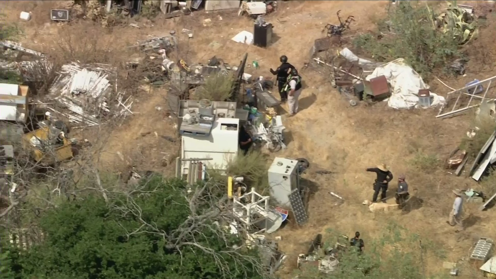 Armed law enforcement enters a property described as a 'junkyard' in Sun Valley