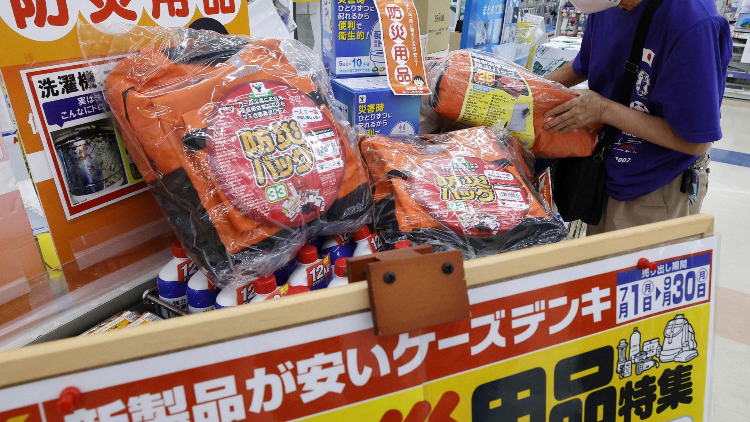 A person checks emergency kit sold at a shop following a strong earthquake in Shibushi, Kagoshima prefecture, southern Japan, on Aug. 9, 2024. (Kyodo News via AP)