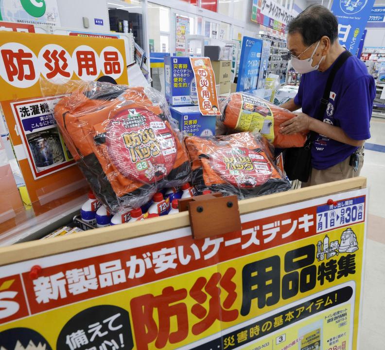 A person checks emergency kit sold at a shop following a strong earthquake in Shibushi, Kagoshima prefecture, southern Japan, on Aug. 9, 2024. (Kyodo News via AP)