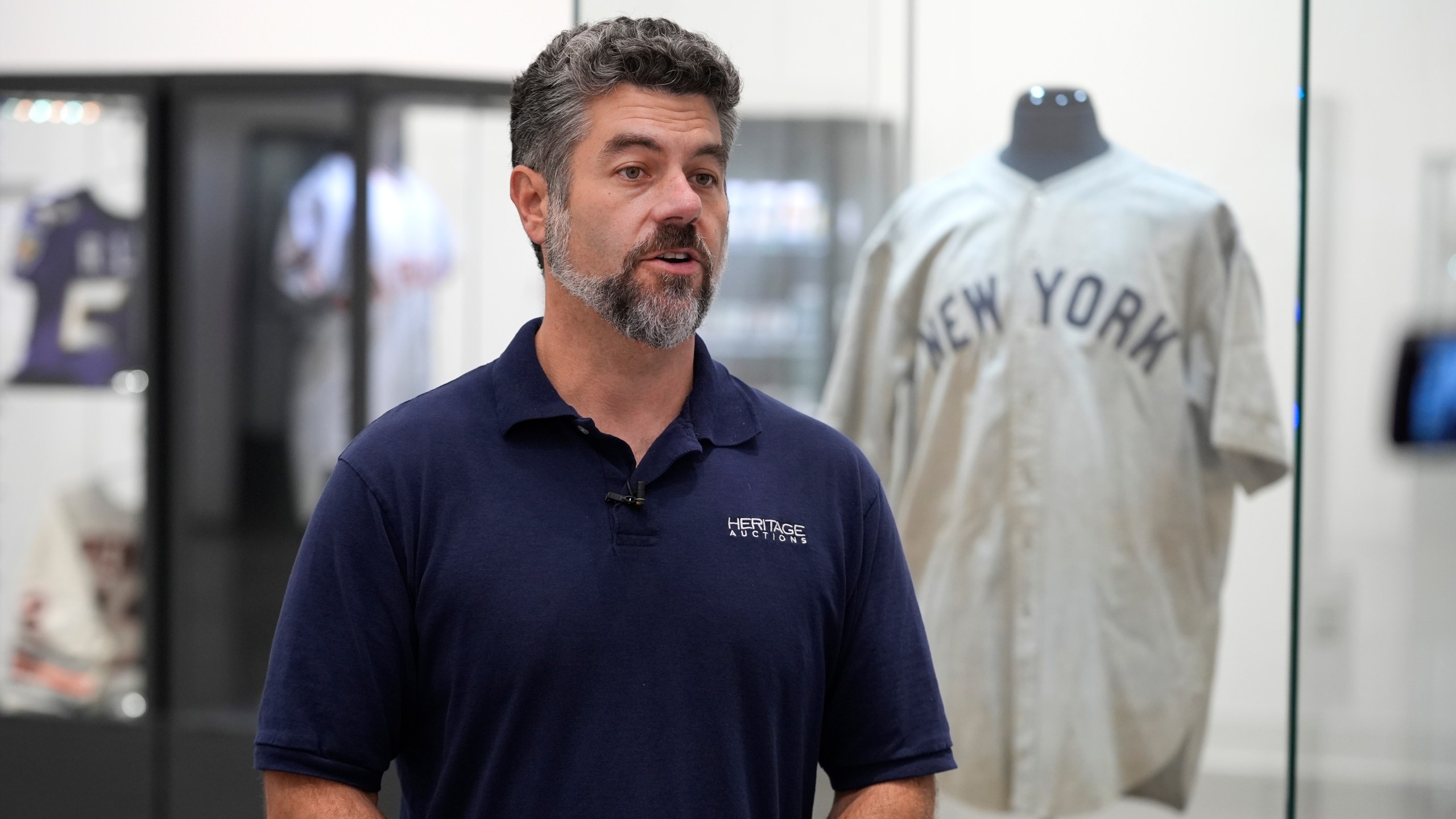 Mike Provenzale, Production manager at Heritage Auctions, talks about the 1932 Babe Ruth game worn New York Yankees World Series "Called Shot" jersey on display at Heritage Auctions in Irving, Texas, Wednesday, Aug. 21, 2024. (AP Photo/LM Otero)