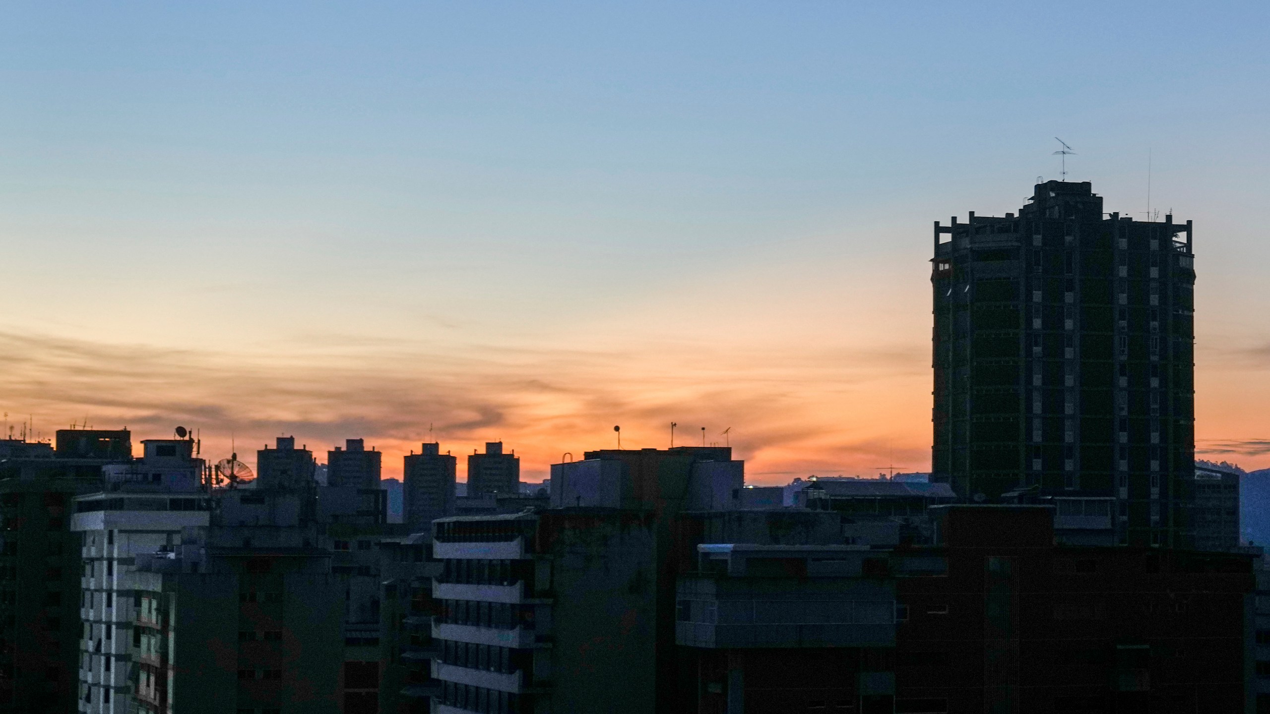 Buildings stand in darkness during a power outage in Caracas, Venezuela, at dawn on Friday, Aug. 30, 2024. (AP Photo/Ariana Cubillos)