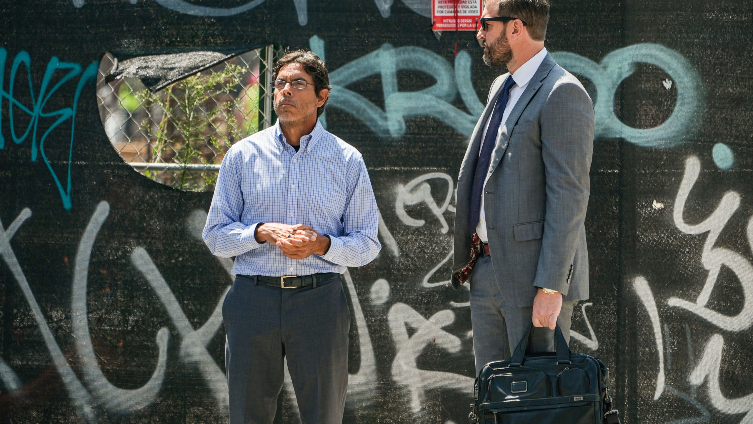 Dr. Mark Chavez, left, a physician from San Diego, who is charged in connection with actor Matthew Perry's death from an accidental ketamine overdose, waits to cross the street with his attorney Matthew Binninger across from the Roybal Federal Courthouse in Los Angeles, Friday, Aug. 30, 2024. (AP Photo/Damian Dovarganes)