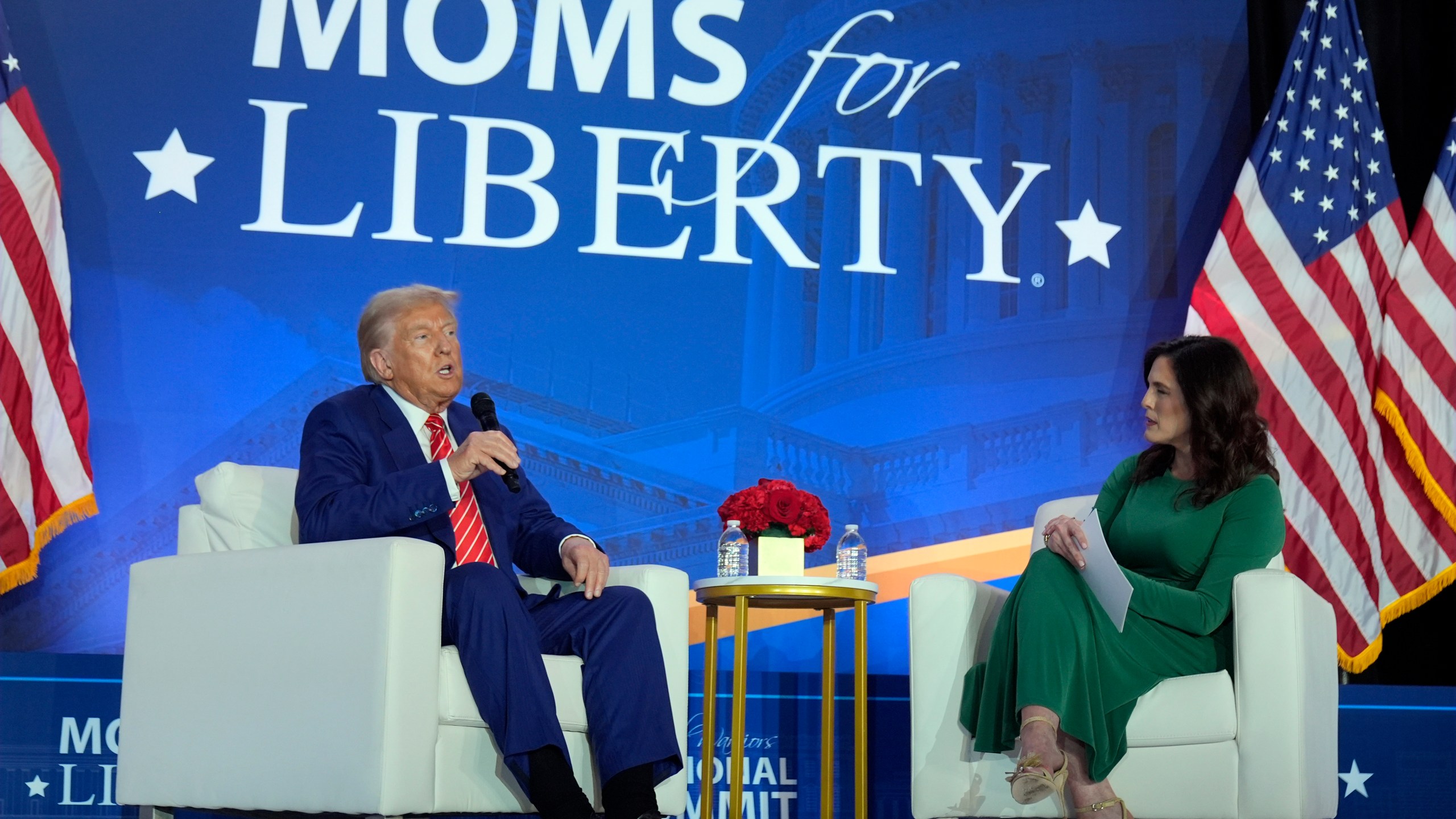 Republican presidential nominee former President Donald Trump speaks with Moms for Liberty co-founder Tiffany Justice during an event at the group's annual convention in Washington, Friday, Aug. 30, 2024. (AP Photo/Mark Schiefelbein)