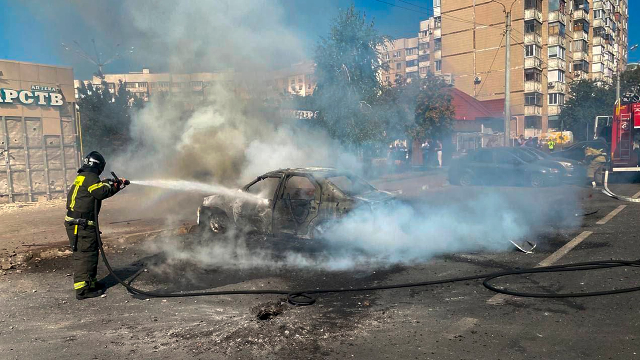 This photo released by Belgorod regional governor Vyacheslav Gladkov's Telegram channel on Sunday, Sept. 1, 2024, firefighters extinguish a burning car in the courtyard of an apartment building after a missile attack by the Armed Forces of Ukraine on the city of Belgorod and the Belgorod region of Russia. (Belgorod Region Governor Vyacheslav Gladkov Telegram channel via AP)