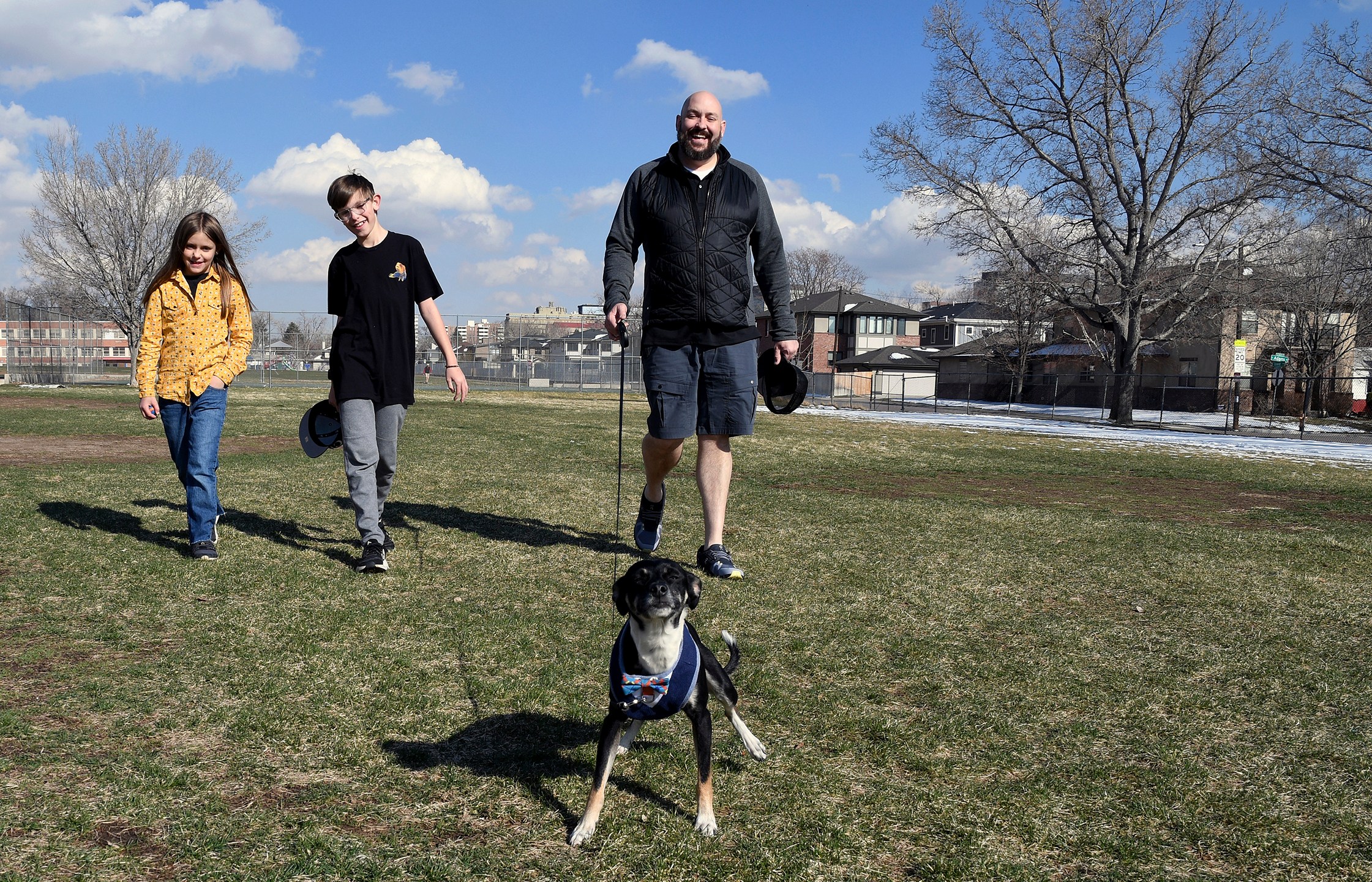 =Ben Cochell, a volunteer for PAWsitive Recovery, walks his foster dog Dexter with his family in Denver on Tuesday, March 26, 2024. (AP Photo/Thomas Peipert)